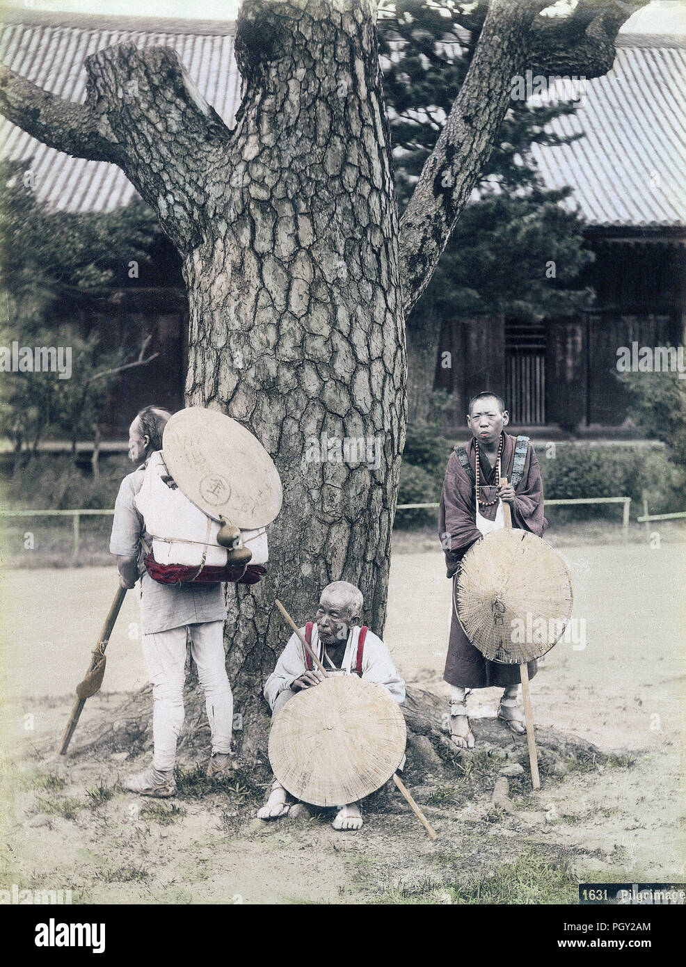 [1880s Japan - buddhistische Pilger ruhen auf Tempel] - Drei Pilger sind ruhen auf einem Verwitterten Kiefer in, was scheint, die Begründung eines buddhistischen Tempel. Sie tragen weiße Gewänder, sugegasa (segge - gewebt Hüte) und waraji (Stroh Sandalen). Sie sind auch mit langen Stöcken und primitiven Rucksäcke tragen. Sie sind auf einer Pilgerfahrt nach Kotohira-gu Schrein, besser als konpira-san, in der Präfektur Kagawa bekannt. 19 Vintage albumen Foto. Stockfoto