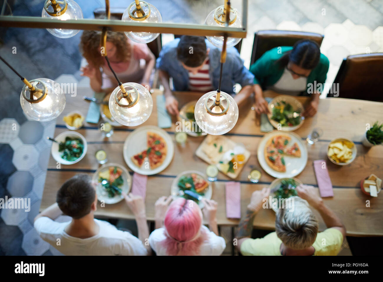 Blick auf Lampen über serviert Tisch mit Essen und einigen Freunden sitzen während der Mittagspause hängen Stockfoto