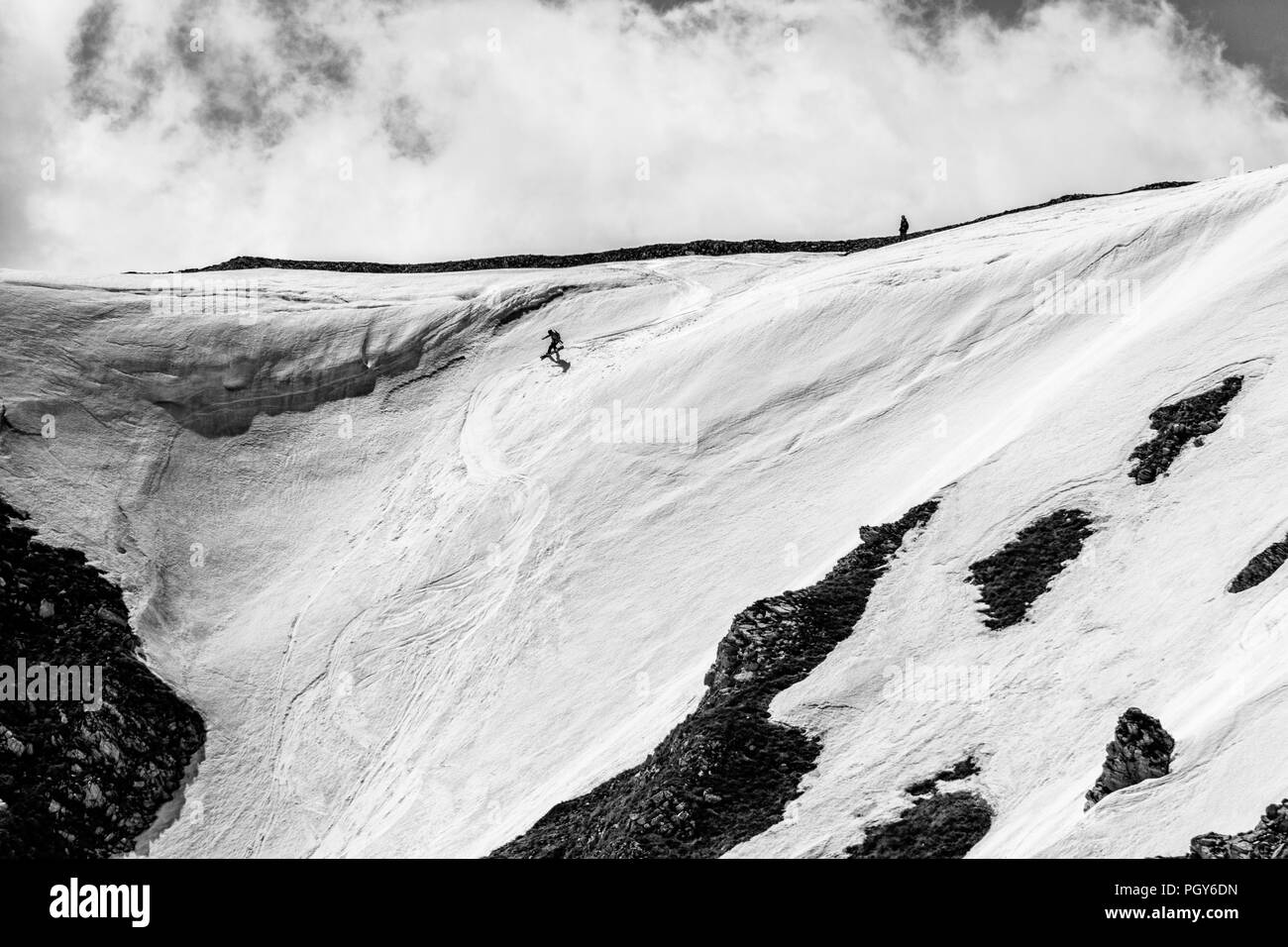 Ein freeride Snowboarder, der Sprung von einer Klippe und macht seinen Trick Stockfoto