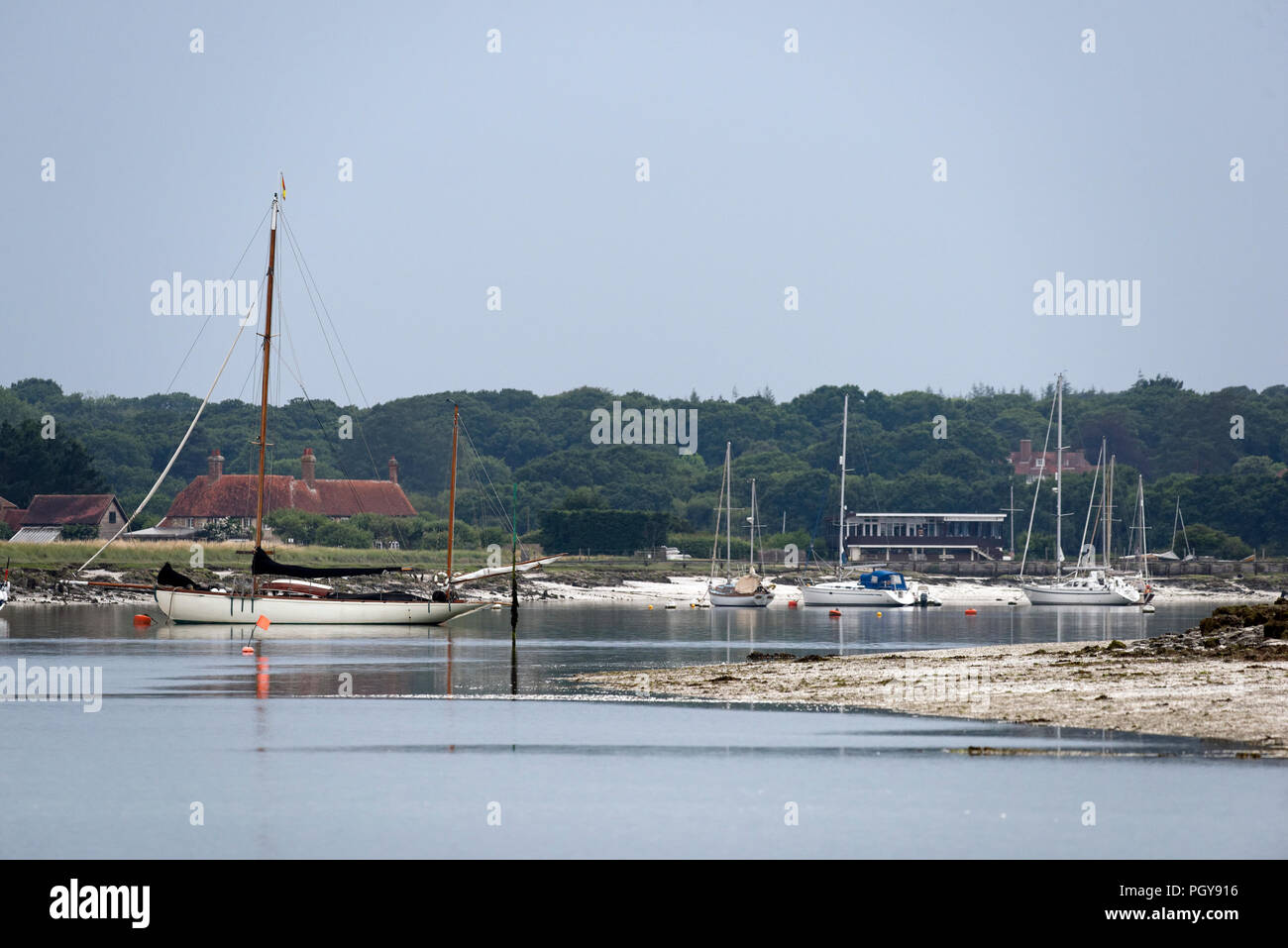 Ein ruhiger Sommer Tag am Unterlauf der Beaulieu River mit angelegten Yachten und die Royal Southampton Yacht Club Gebäude an Gins Farm. Stockfoto