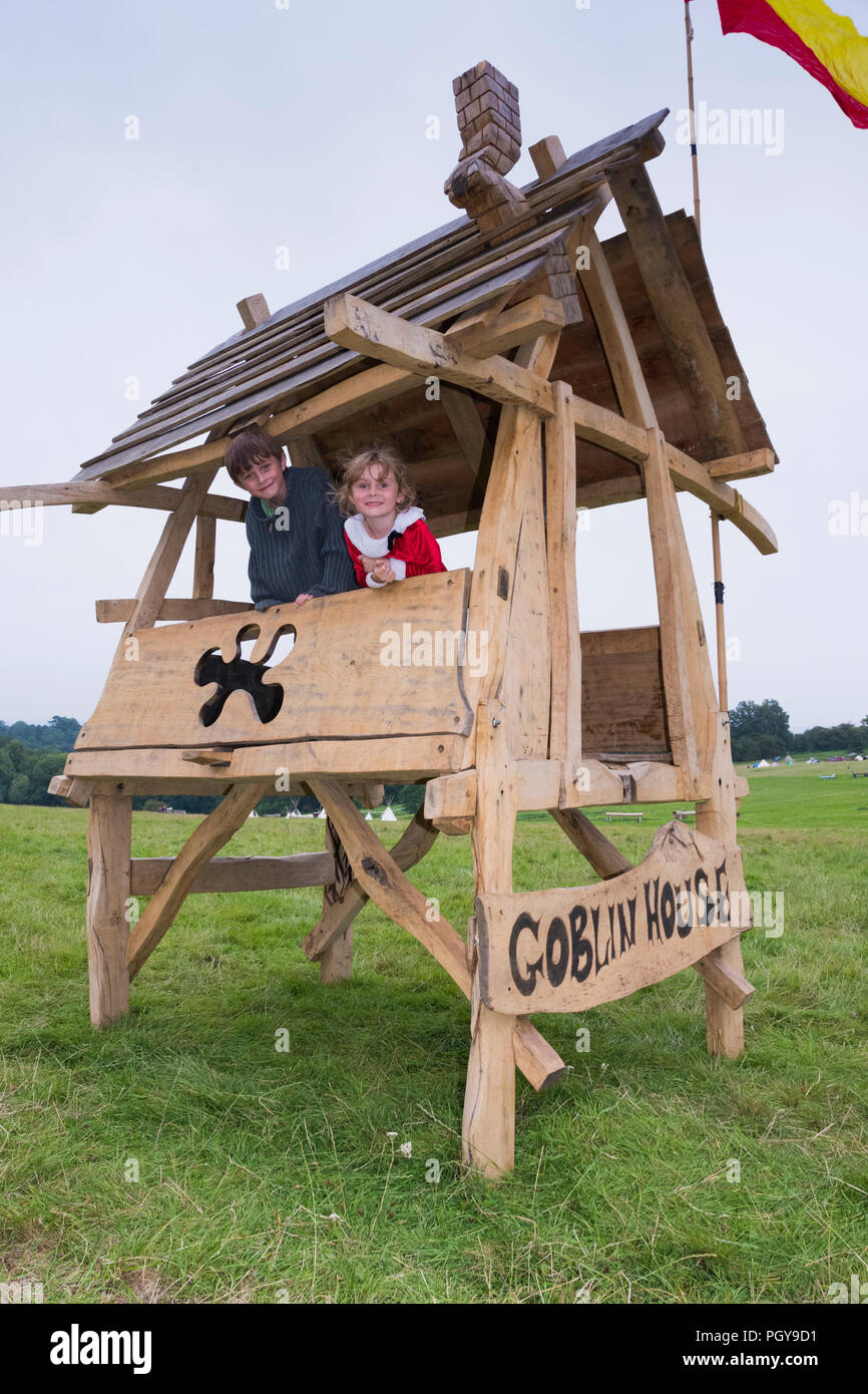 Newport, Wales - 23 Aug 14: Zwei Kinder peer aus dem Goblin Haus Holz Spielhaus am 14. August 2015 Im Green Gathering Festival Stockfoto