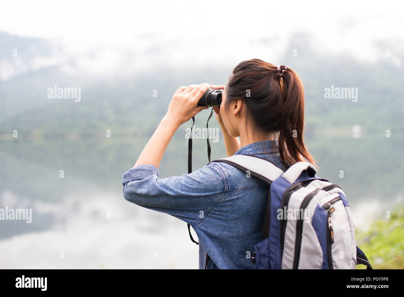 Thai Abenteuer Mädchen beobachtet mit einem Fernglas am See Stockfoto