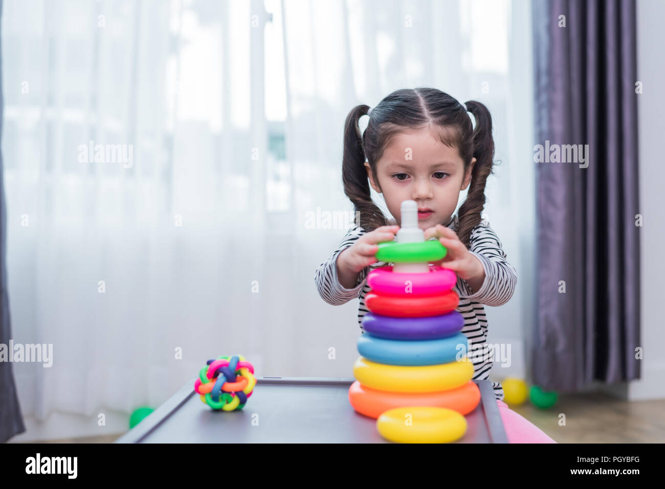 Kleine Mädchen spielen kleines Spielzeug Bänder in Home Kleine Mädchen spielen kleines Spielzeug Bänder in Home