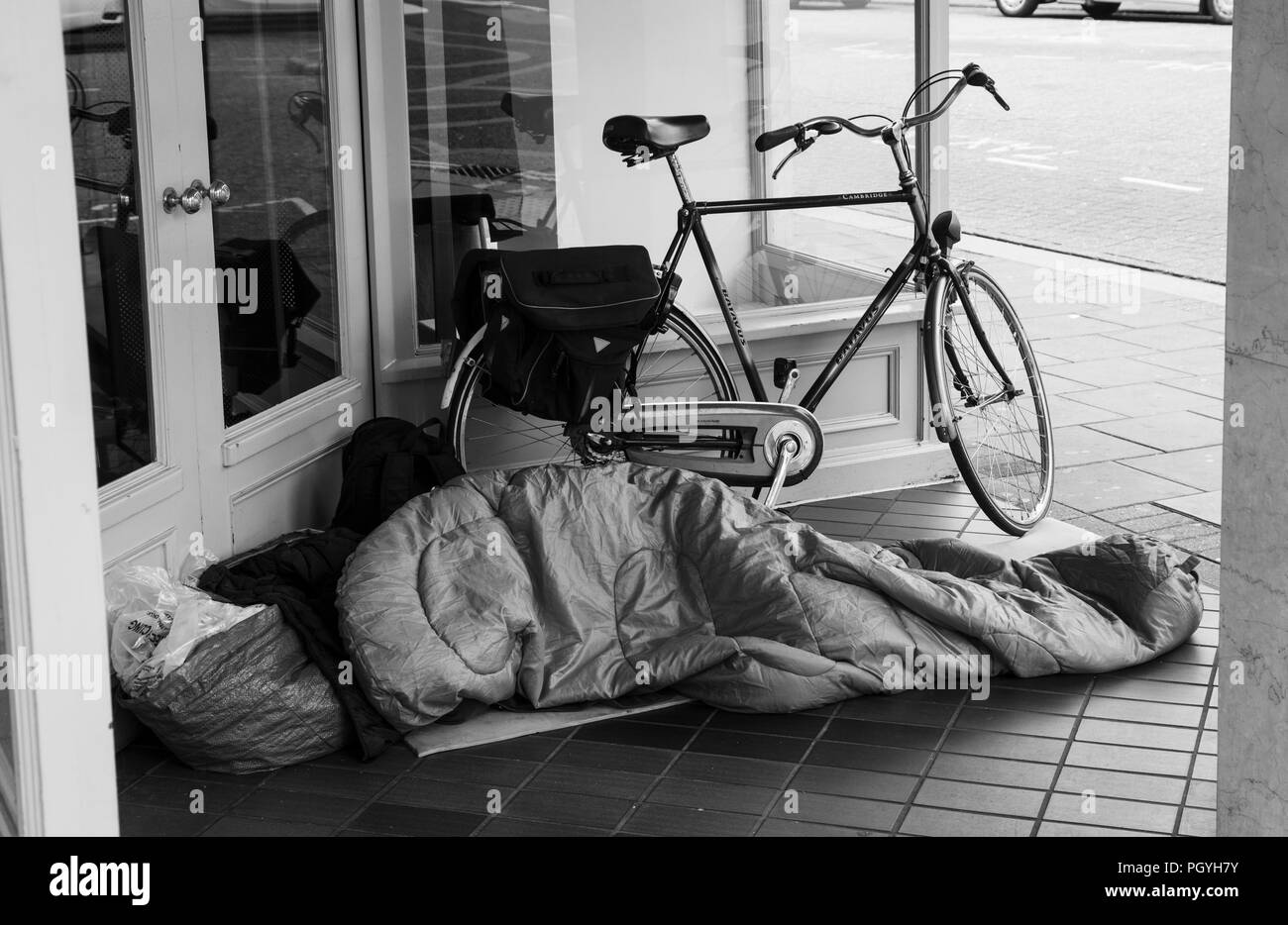 Schwarz-weiß Bild von Obdachlosen schläft im Shop Eingang Stockfoto