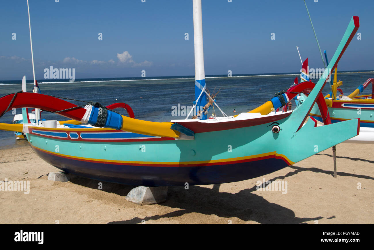 Grün mit dunklen blau gefärbten Fischerboot liegt am weißen Sandstrand von Sanur auf Bali, Indonesien. Mit dem Meer in der indonesischen mit dem Meer auf den hinterg Stockfoto