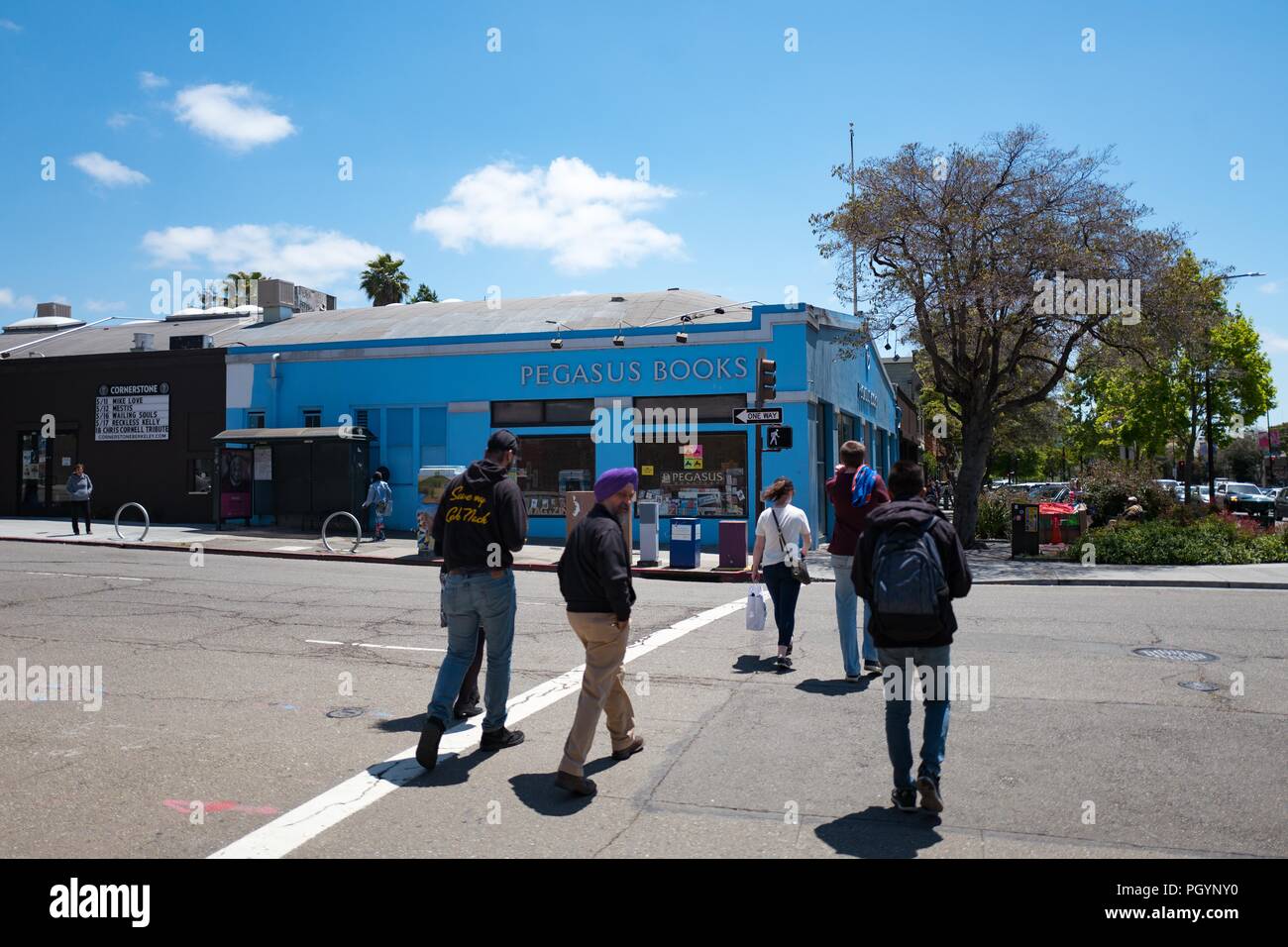 Eine Gruppe von Menschen überqueren die Straße und gehen Sie in Richtung Pegasus Bücher, eine klassische unabhängige Buchhandlung in der Innenstadt von Berkeley, Kalifornien, 17. Mai 2018. () Stockfoto