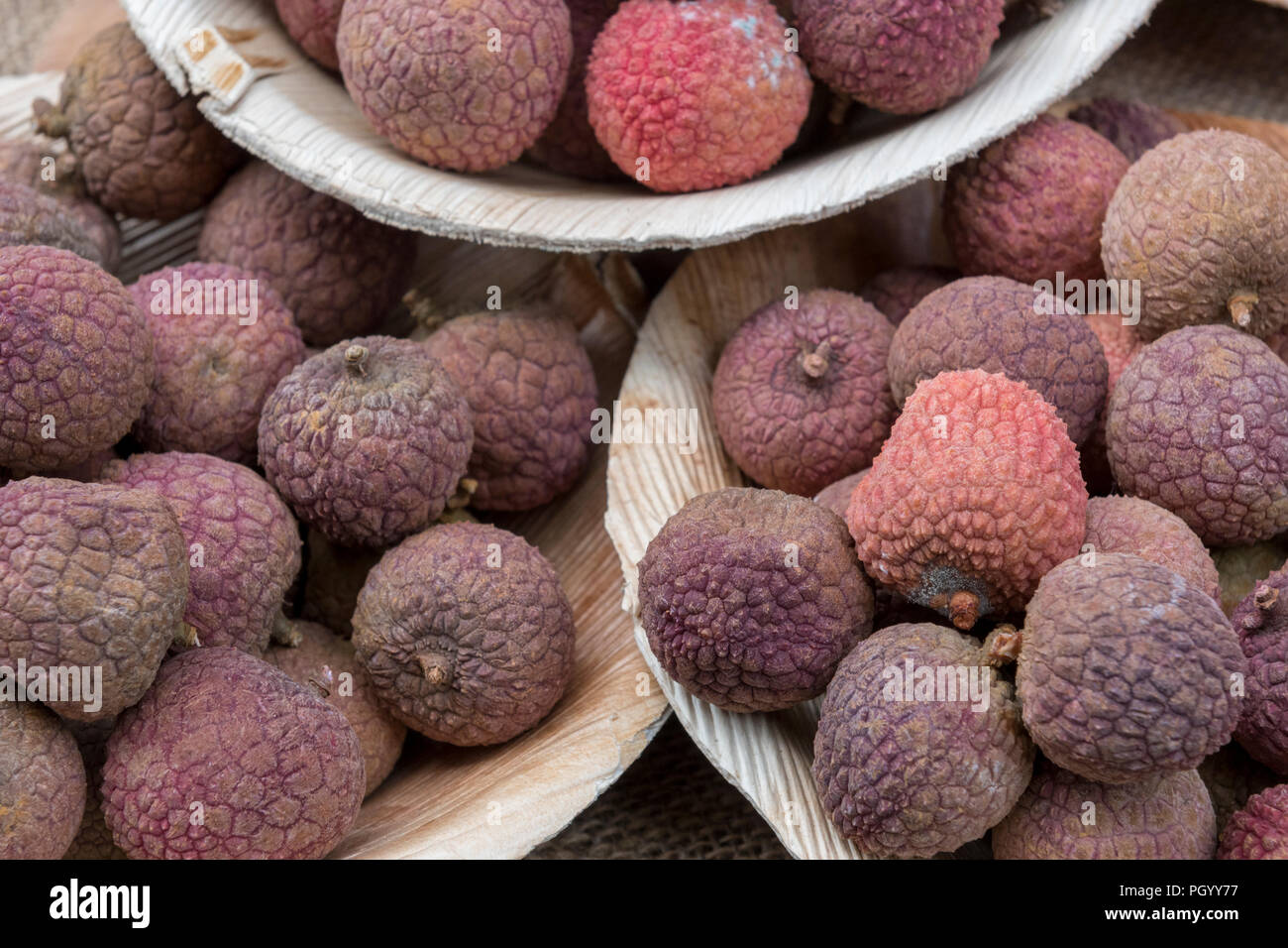 Frisch gepflückt und bunten Litschis auf Verkauf in Schalen mit Obst und Gemüse Markt. Stockfoto