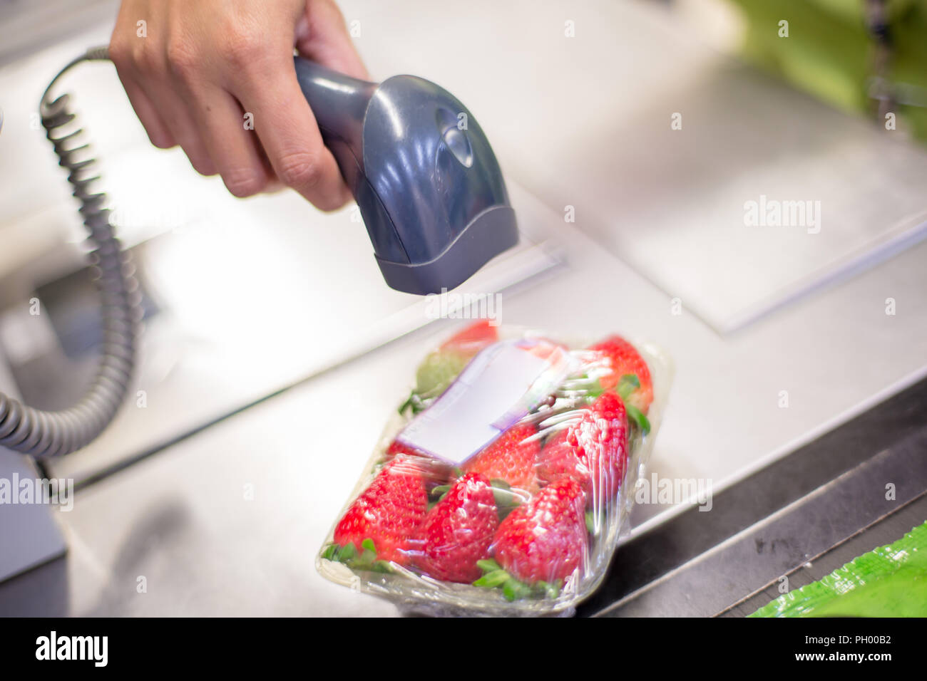 Bar Code Reader lesen Sie den Code eines Pakets von Erdbeeren auf der Kasse in einem Supermarkt Stockfoto