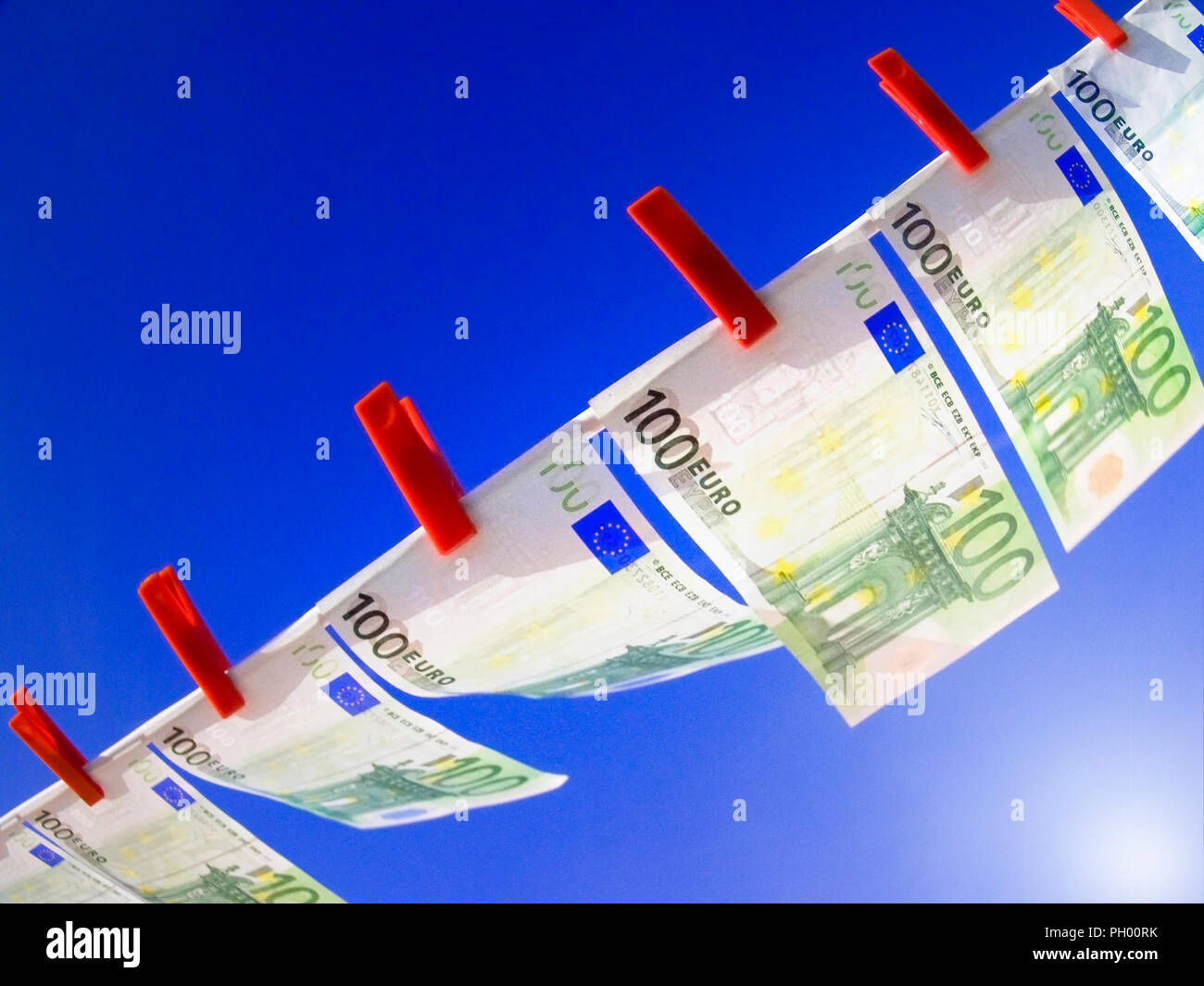 Konzept WÄHRUNG EUROZONE ZUKUNFT LEITZINSEN 21.05.2011 BREEZE INVESTITIONEN 100 wert Bezeichnung Euro nimmt mit rote Heringe flattern im Wind auf der Linie gegen Sunburst und blauer Himmel Stockfoto