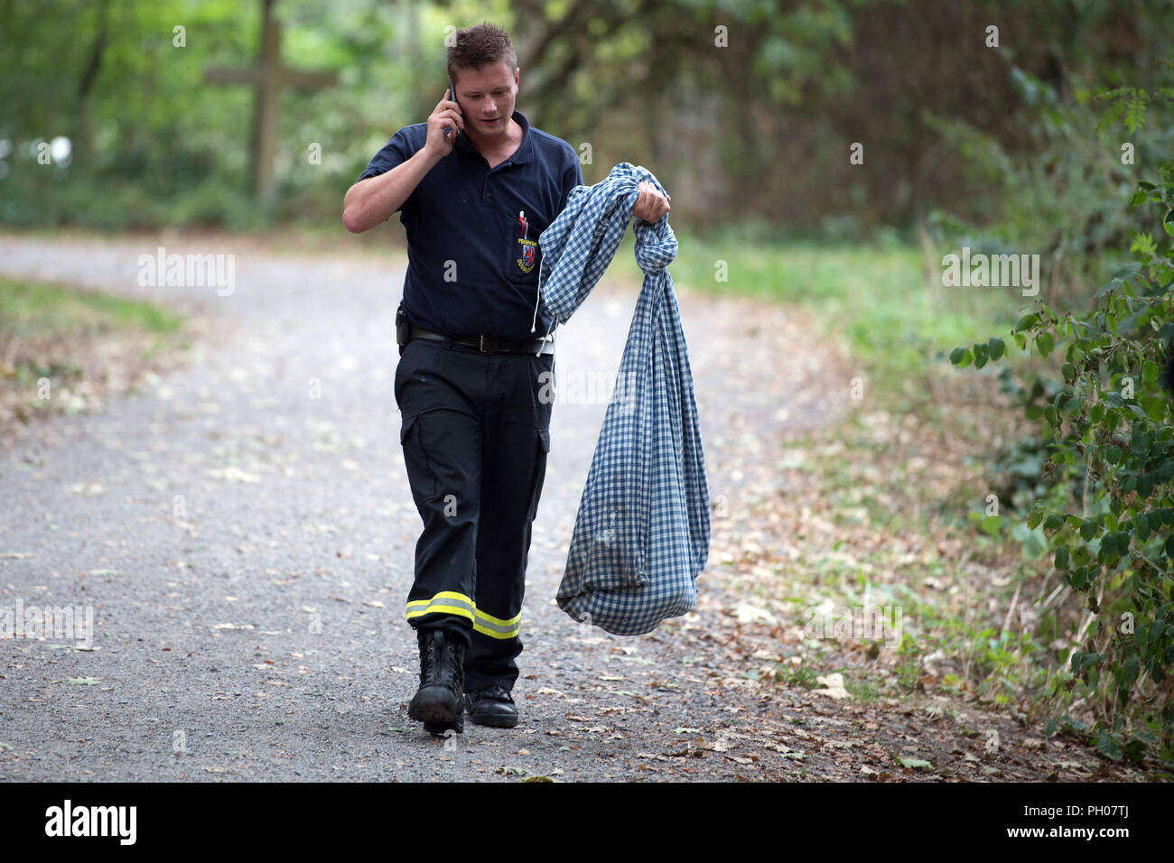 Deutschland, Meerbusch. 29 Aug, 2018. Chief Feuerwehrmann und Schlange Experte der Düsseldorfer Feuerwehr Sebastian Schreiner trägt die erfassten Gelbe Anakonda in der Tasche. Sie war im See Latum in Meerbusch bei Düsseldorf. Ein Sprecher der Stadt Meerbusch, sagte am Mittwoch, dass das Reptil Experte der Düsseldorfer Feuerwehr der Choke Schlange mit einem Greifer vom Boot aus gefangen. Sie sonnen sich am Ufer in einer Black Bush. Das Tier ist 2,40 Meter lang. Credit: Federico Gambarini/dpa/Alamy leben Nachrichten Stockfoto