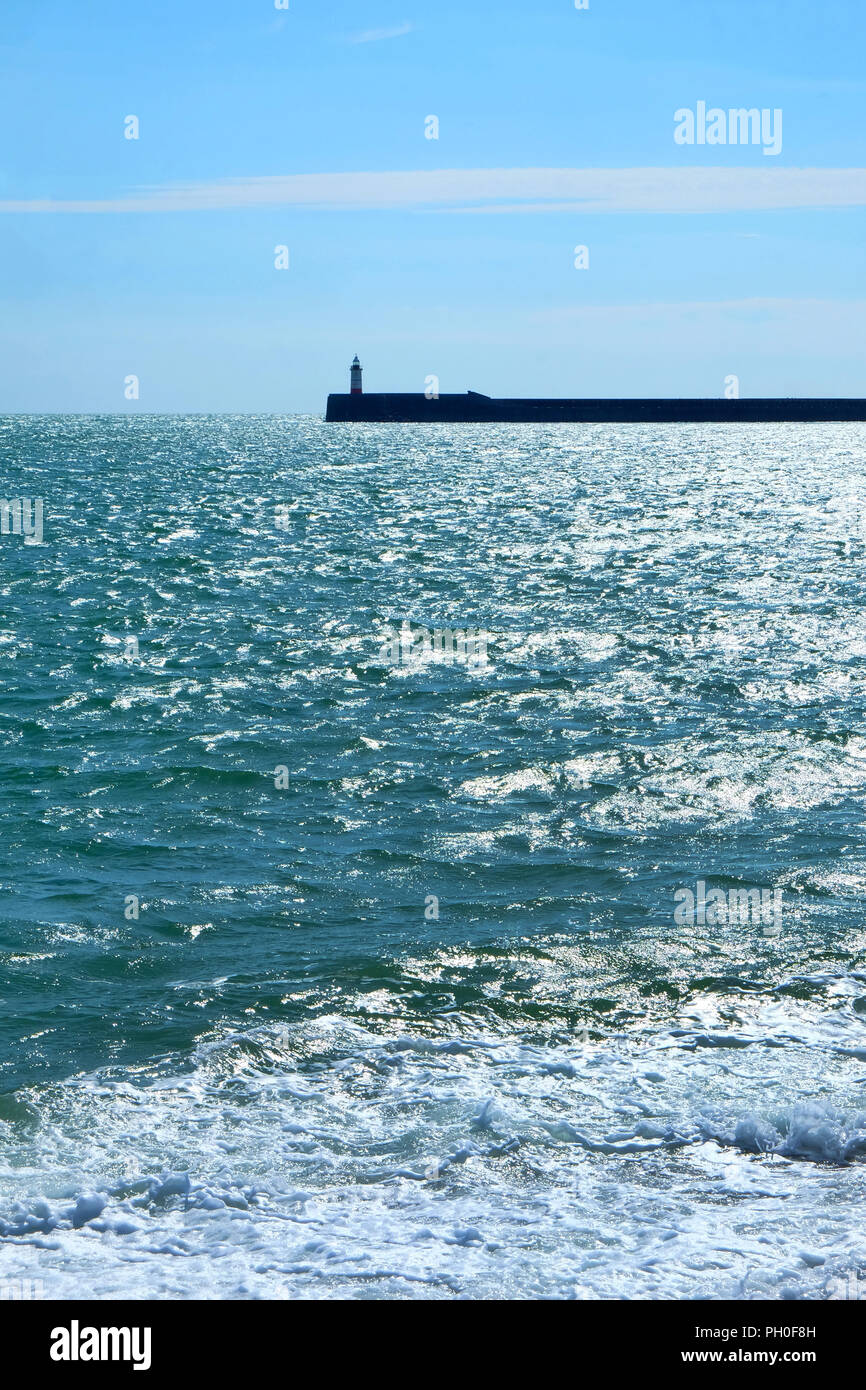 Die laboe Leuchtturm und Hafen Wand sind in der Mitte mit einem blauen sonnenbeschienenen Meer im Vordergrund und blaue und weiße Wolken im Hintergrund vertic Stockfoto