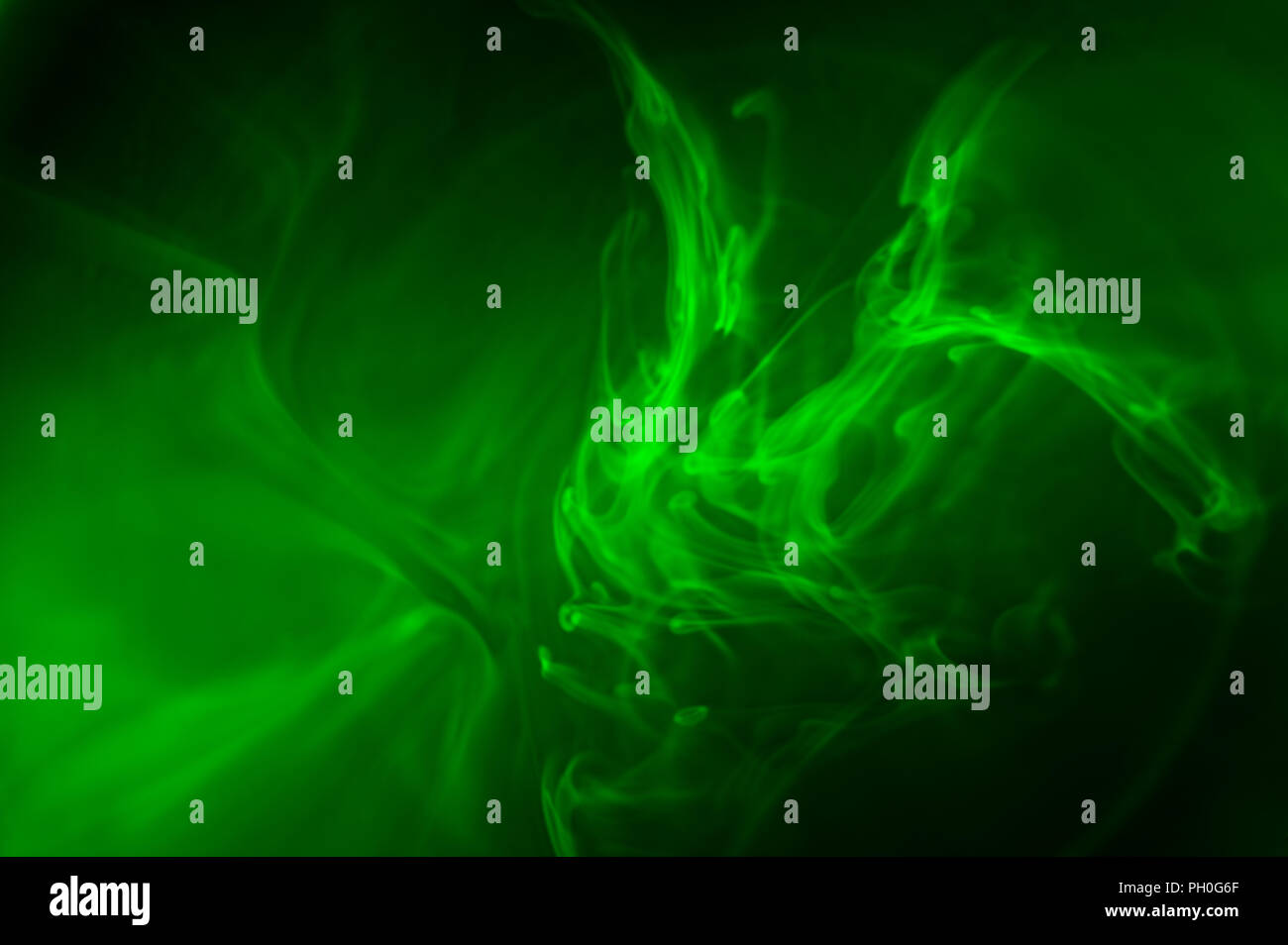 Ruhe diffusionsmuster von dispergieren Fluorescein in Wasser durch Fluoreszenz von Schwarzlicht UV verursacht, die unheimliche Glühen und wirbelnden Flüssigkeit Stockfoto