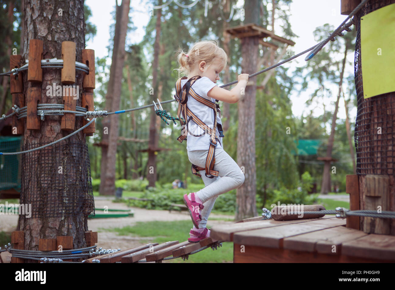 Aktive Erholung. Kleines Mädchen Spaß im Seilpark. Stockfoto
