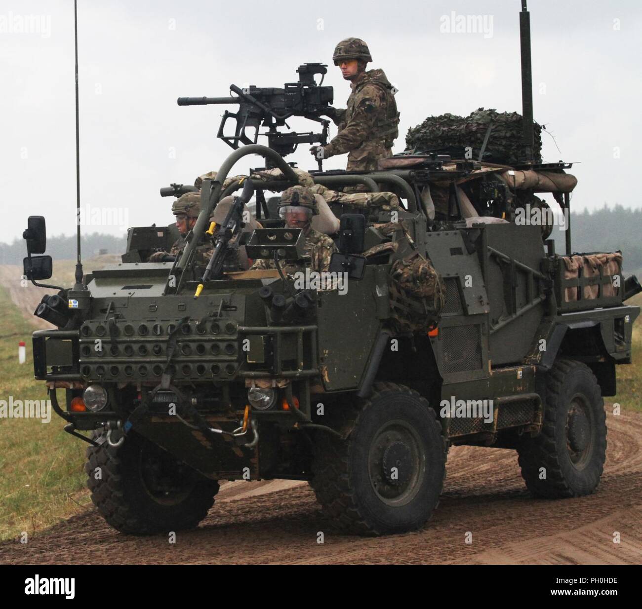 Eine britische Mobilität Weapon-Mounted Installation Kit "Schakal" mit Battle Group Polen, hinterlässt eine Staging Area und Schritte in Richtung auf ein live-Fire Training als Teil ihrer Beteiligung an Sabre Streik 18 an der Bemowo Piskie Training Area 14. Juni 2018. Sabre Streik 18 ist der achte Iteration des langjährigen US-Army Europe - LED-kooperative Ausbildung übung, die Interoperabilität zwischen den Verbündeten und Partnern in der Region zu verbessern. (Michigan Army National Guard Stockfoto