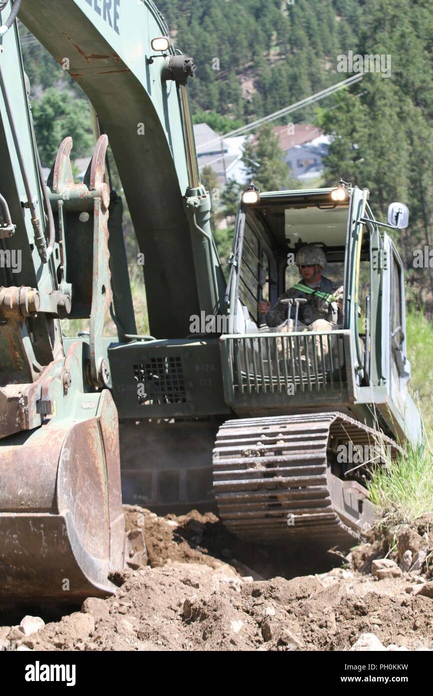 Us-Armee Cpl. Quincy Barlow mit 842Nd die South Dakota Army National Guard Ingenieur Gesellschaft betreibt ein Hydraulikbagger zu Hang Wasser flow control und Straße Auswaschung am Sanford unterirdischen Forschungseinrichtung während des goldenen Coyote Training führen, S.D., 15. Juni 2018 zu verhindern. Dies ist eine von vielen Ingenieur Projekte und den humanitären Dienst Missionen, die während der Goldenen Coyote Ausbildung Übung nehmen. Stockfoto