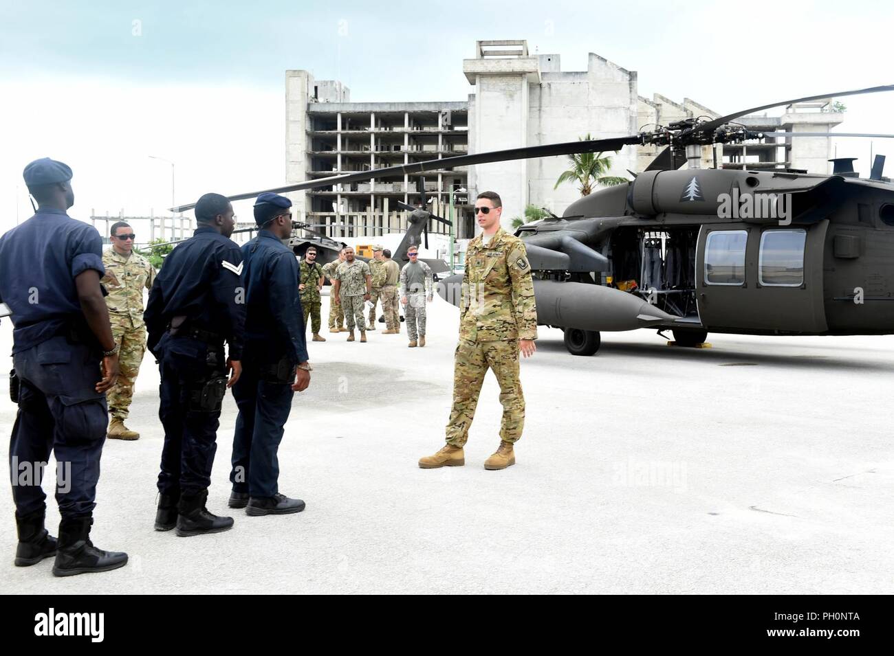 Bahamas (17. Juni 2018) U.S. Army Sgt. Jordan Ford, New Hampshire Army National Guard 1 Battallion, 169Th Aviation Regiment, beschreibt die Verfahren für die sichere Durchführung von Truppe Be- und Entladen eines UH-60 Blackhawk Helikopter mit Royal Bahamas Polizei spezielle Waffen und Taktiken (SWAT) Teammitglieder während der Einarbeitung und kalt - last Schulungsveranstaltung an Bord der Royal Bahamas's Defence Force Coral Harbour Base als Teil der Tradewinds 2018. Tradewinds ist ein US Southern Command gesponsert Übung, die Teilnehmenden die karibischen Staaten, die Möglichkeit, die Sicherheit zu verbessern und Stockfoto