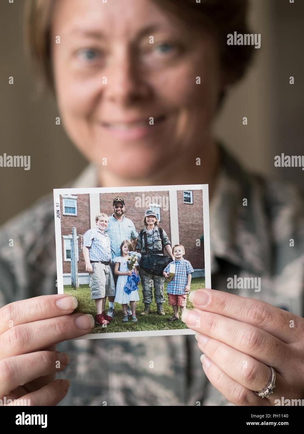 Airman 1st Class Crystal Jenkins, ein Fotojournalist, der 673 d Air Base Wing öffentlichen Einheit Angelegenheiten zugewiesen, hält ein Foto von ihr und ihrer Familie nachdem Sie von der Defense Information School in Fort Meade, Md., 2017. Jenkins war inspiriert der US Air Force während der 2016 Arctic Thunder Open House bei Joint Base Elmendorf-Richardson, Alaska zu verbinden. Nachdem die Anwerbung im Jahr 2016 war sie die Gelegenheit gegeben, zu der sie von eingezogen wurde, zurückzukehren. Stockfoto