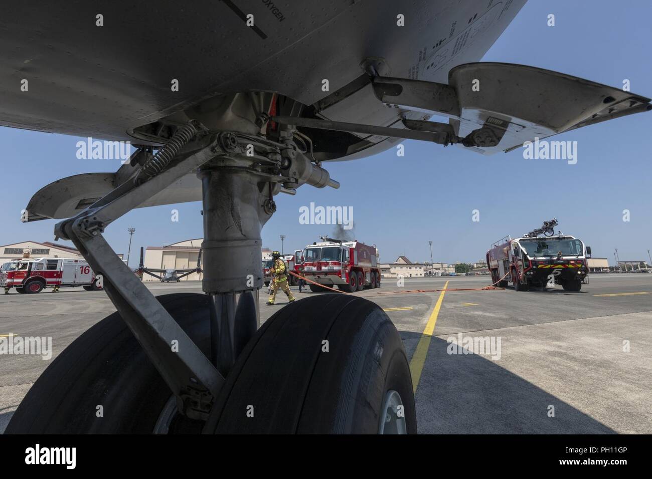 Feuerwehrmänner mit dem 374 Bauingenieur Squadron reagieren auf einen simulierten Brand an Bord einer C-17 Globemaster III während ein Notfallplan Übung in Yokota Air Base, Japan, 25. Juni 2018. Flieger von der 730th Air Mobility Squadron und 374 CES Feuerwehr führte eine simulierte Feuer an Bord einer C-17 und Einarbeitung Training. Stockfoto