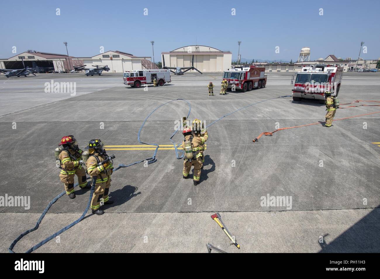 Feuerwehrmänner mit dem 374 Bauingenieur Squadron bereiten einen simulierten Brand an Bord einer C-17 Globemaster III während ein Notfallplan Übung in Yokota Air Base, Japan, 25. Juni 2018 zu kämpfen. Flieger von der 730th Air Mobility Squadron und 374 CES Feuerwehr führte eine simulierte Feuer an Bord einer C-17 und Einarbeitung Training. Stockfoto