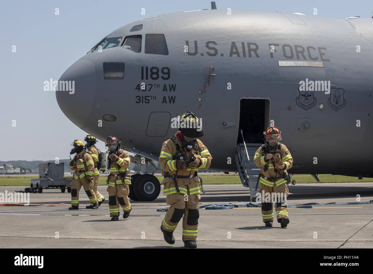 Feuerwehrmänner mit dem 374 Bauingenieur Squadron zurück in die flightline nach Abschluss ein Notfallplan Übung in Yokota Air Base, Japan, 25. Juni 2018. Flieger von der 730th Air Mobility Squadron und 374 CES führte eine simulierte Feuer an Bord einer C-17 und Einarbeitung Training. Stockfoto