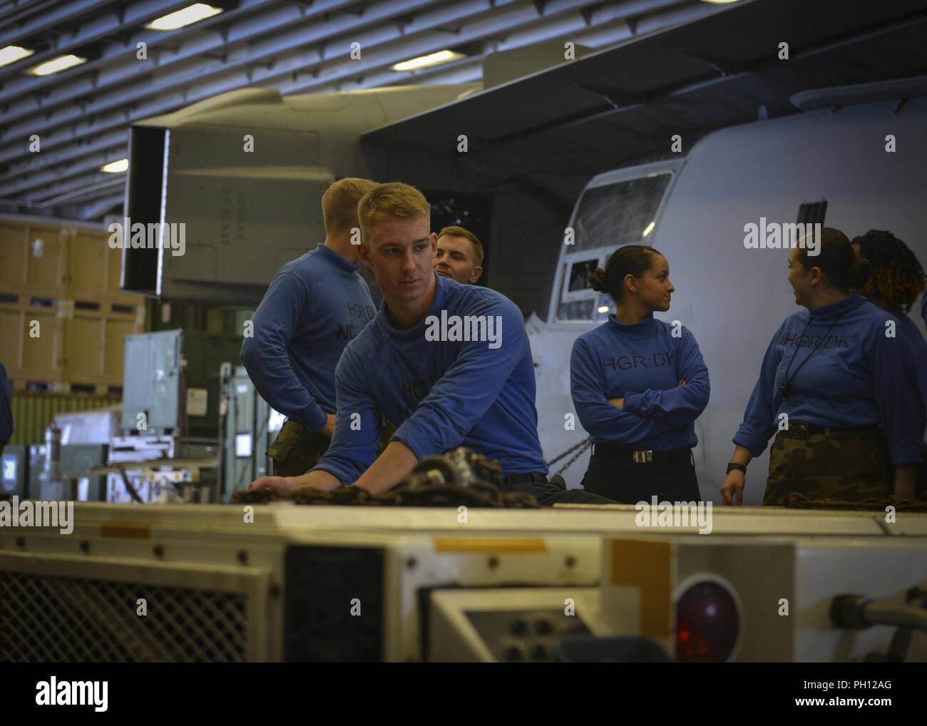 5. Flotte BEREICH VON OPERATIONEN (26. Juni 2018) Flieger Simon Schultz, von Stevens Point, Wisconsin, treibt einen wie 32-32 ein Spotting dolly im Hangar Bucht von der WASP-Klasse amphibisches Schiff USS Iwo Jima (LHD7), 26. Juni 2018. Iwo Jima in Mayport, Fla. homeported, ist auf die Bereitstellung zu den USA 5 Flotte Bereich für Maßnahmen zur Erhöhung der Sicherheit des Seeverkehrs Operationen Verbündeten und Partnern zu beruhigen, und der Freiheit der Schiffahrt und des freien Handels in der Region erhalten. Stockfoto