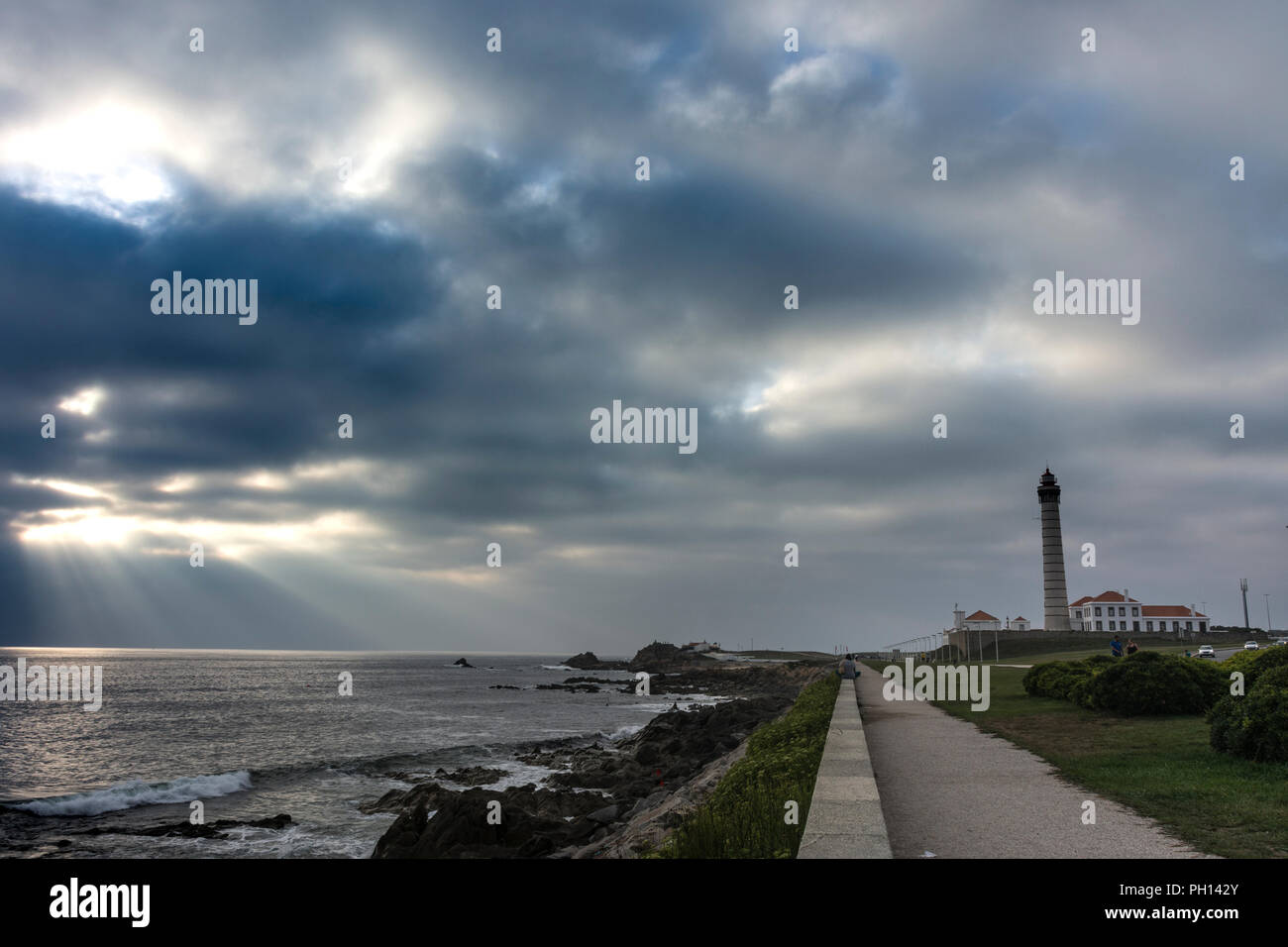 Stürmischer Himmel über der Promenade und den Gärten neben dem Leuchtturm an der felsigen Küste von Leça de Palmeira, Portugal Stockfoto