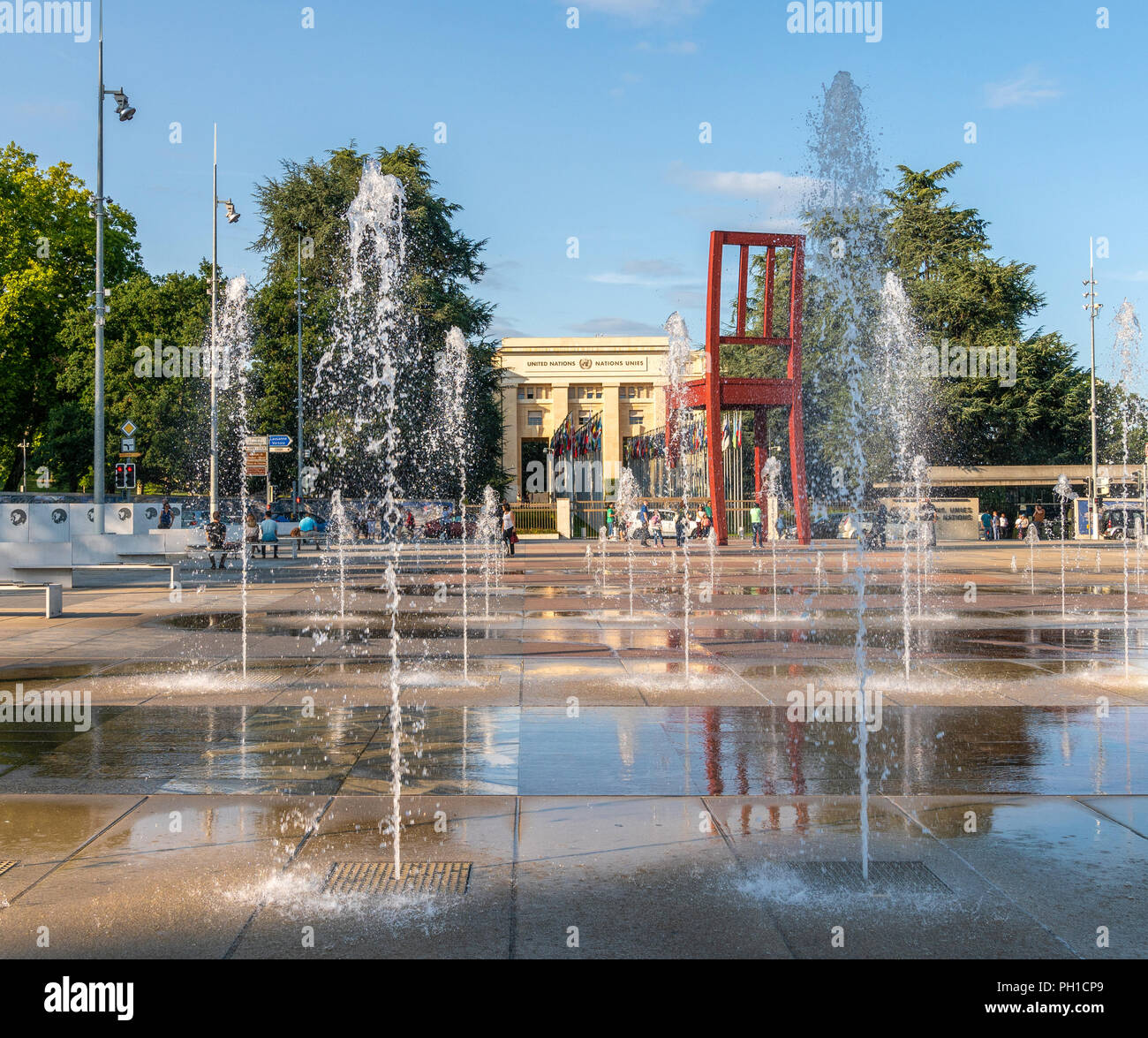 27. August 2018 - Genf, Schweiz. Der Ort des Nations Wasserstrahlen Feder aus dem Boden. Das Quadrat ist die Heimat der "Broken Chair" ein Symbol Stockfoto