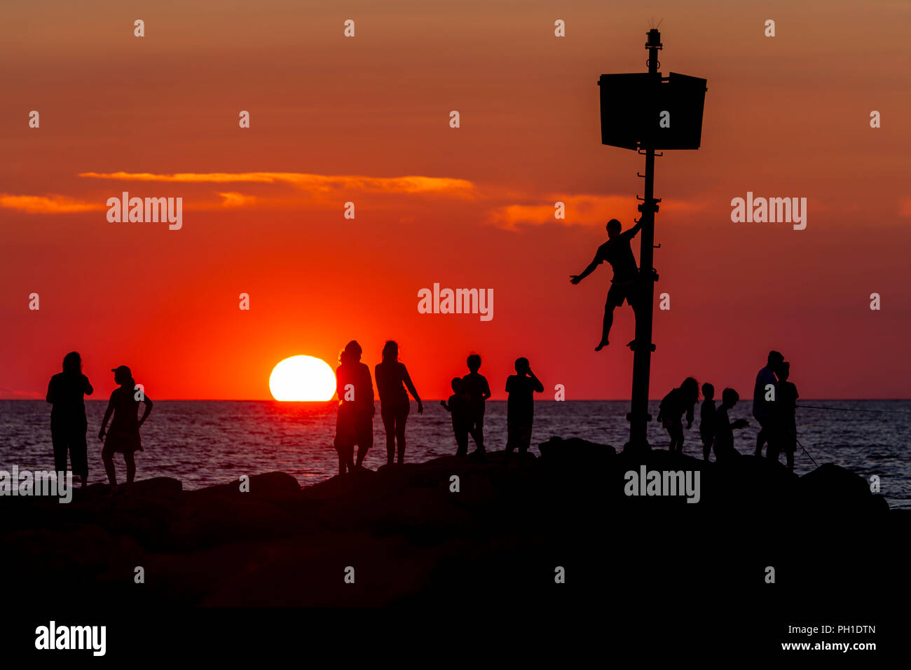 Die Menschen auf der Mole, angeln, und der Sonnenuntergang an menemsha Strand in Chilmark, Massachusetts auf Martha's Vineyard. Stockfoto