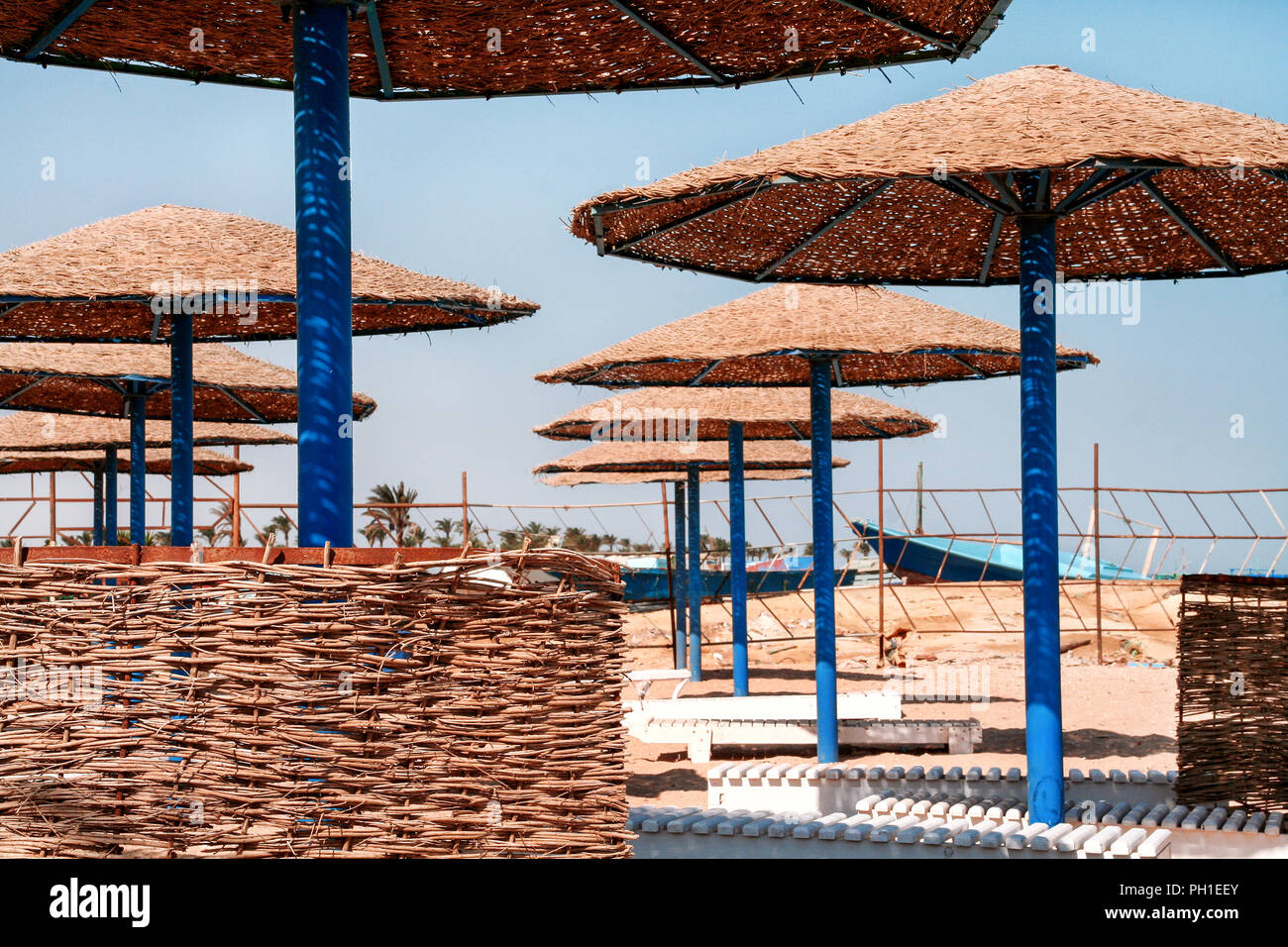 Bambus Sonnenschirm am Strand gypten. Sonnenschirm auf dem Hintergrund des  blauen Himmels Stockfotografie - Alamy
