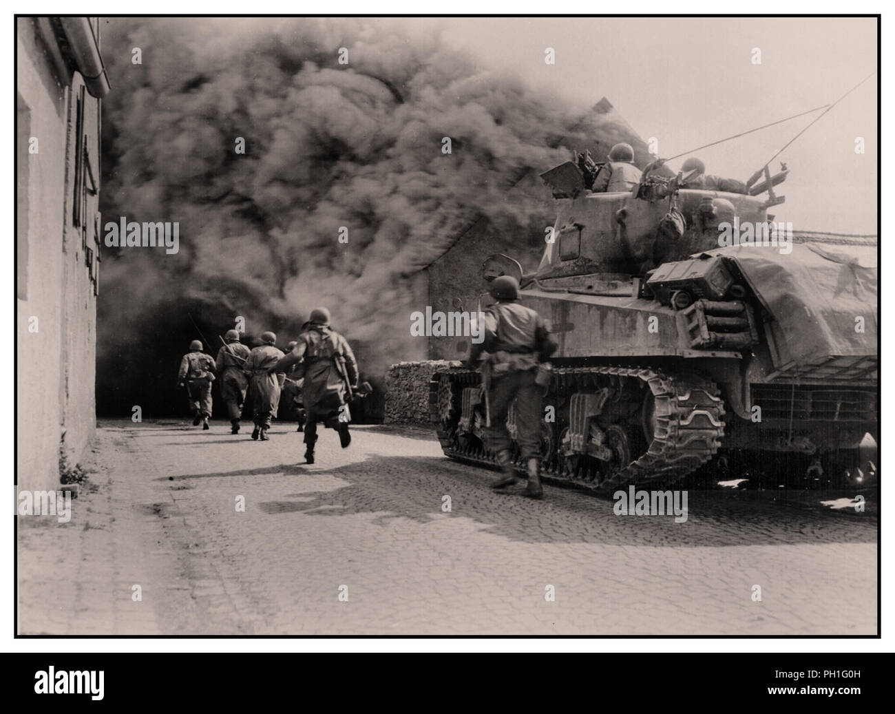 WW2 GI Soldaten der 55th Armored Infantry Battalion dritte Armee und M4 Sherman Panzer der 22 Tank Bataillon, Vorauszahlung durch Rauch Straße. Wernberg, Deutschland. 22. April 1945 Stockfoto