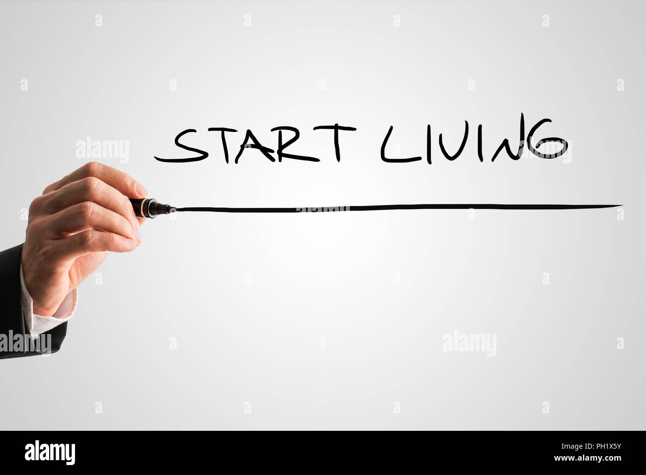 Mann Schreiben der Wörter - zu leben beginnen - mit einem schwarzen Filzstift hinter einer virtuellen Bildschirm oder Schnittstelle auf einem hellgrauen Hintergrund mit Copyspace, Cl Stockfoto