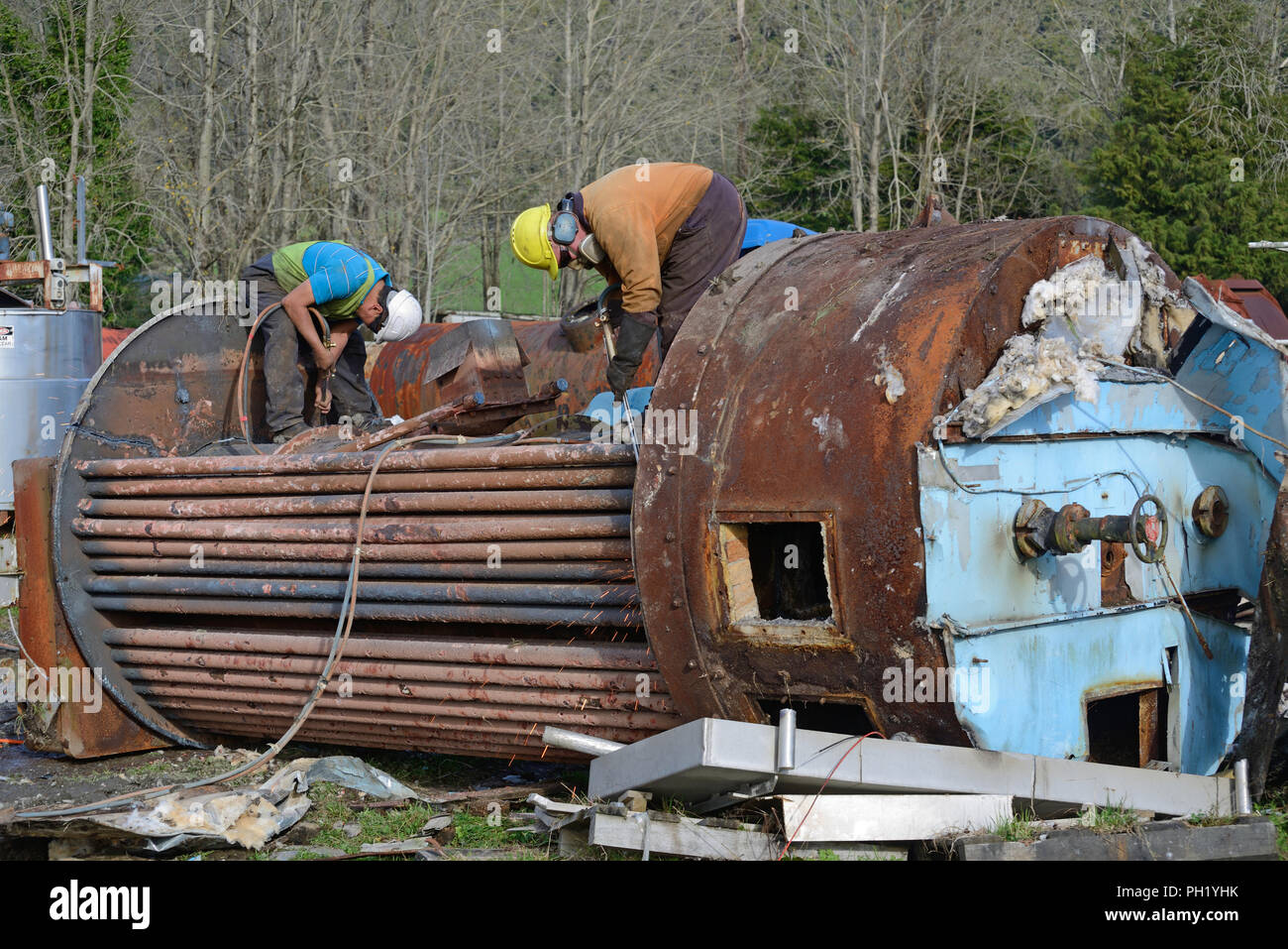 Greymouth, Neuseeland, 14. Mai 2018: Eine nicht identifizierte Ingenieur Schnitte, eine alte Kessel für Schrott Stockfoto