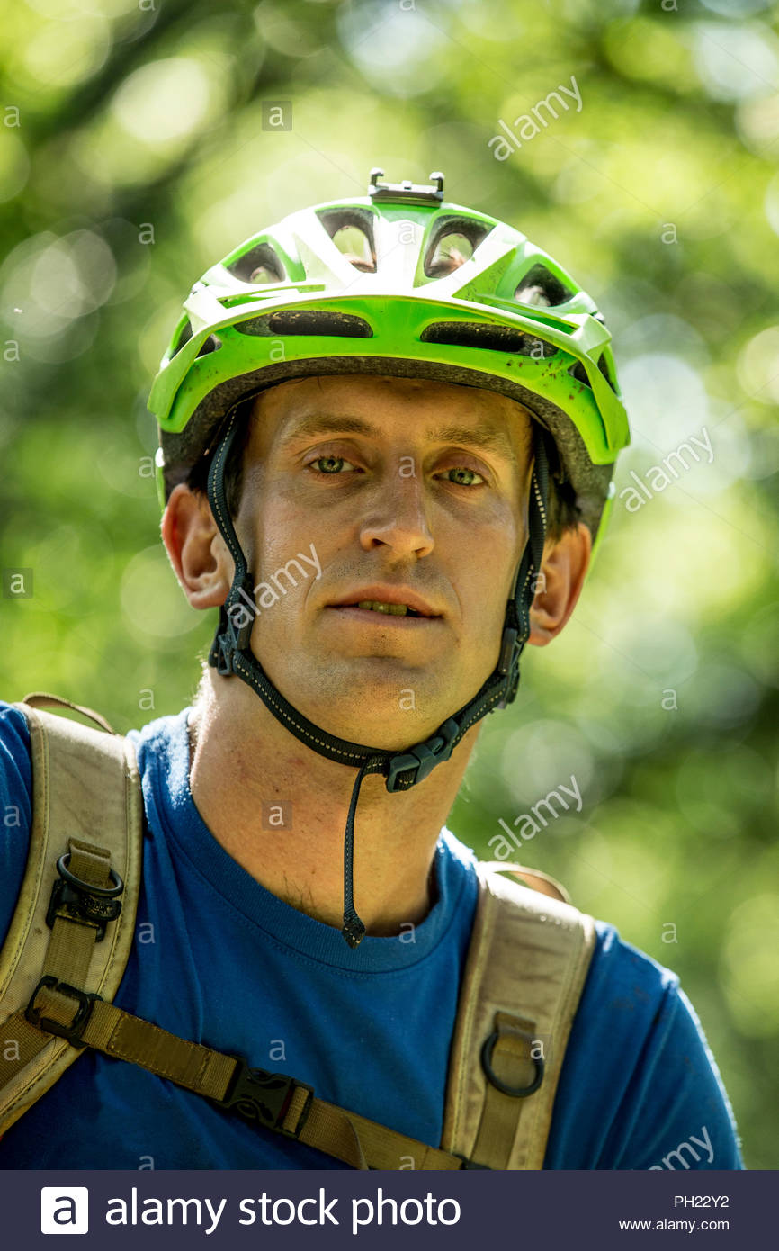 Junger Mann mit Fahrrad Helm im Wald Stockfotografie - Alamy