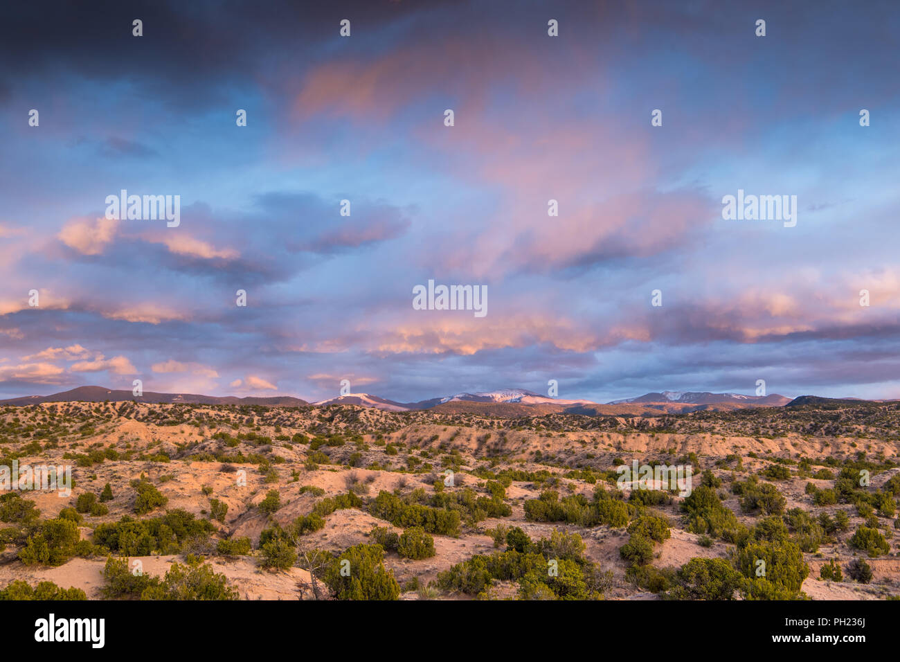 Dramatische bunte Wolken bei Sonnenuntergang über der Sangre de Cristo Bergen und Wüste in der Nähe von Santa Fe, New Mexico Stockfoto