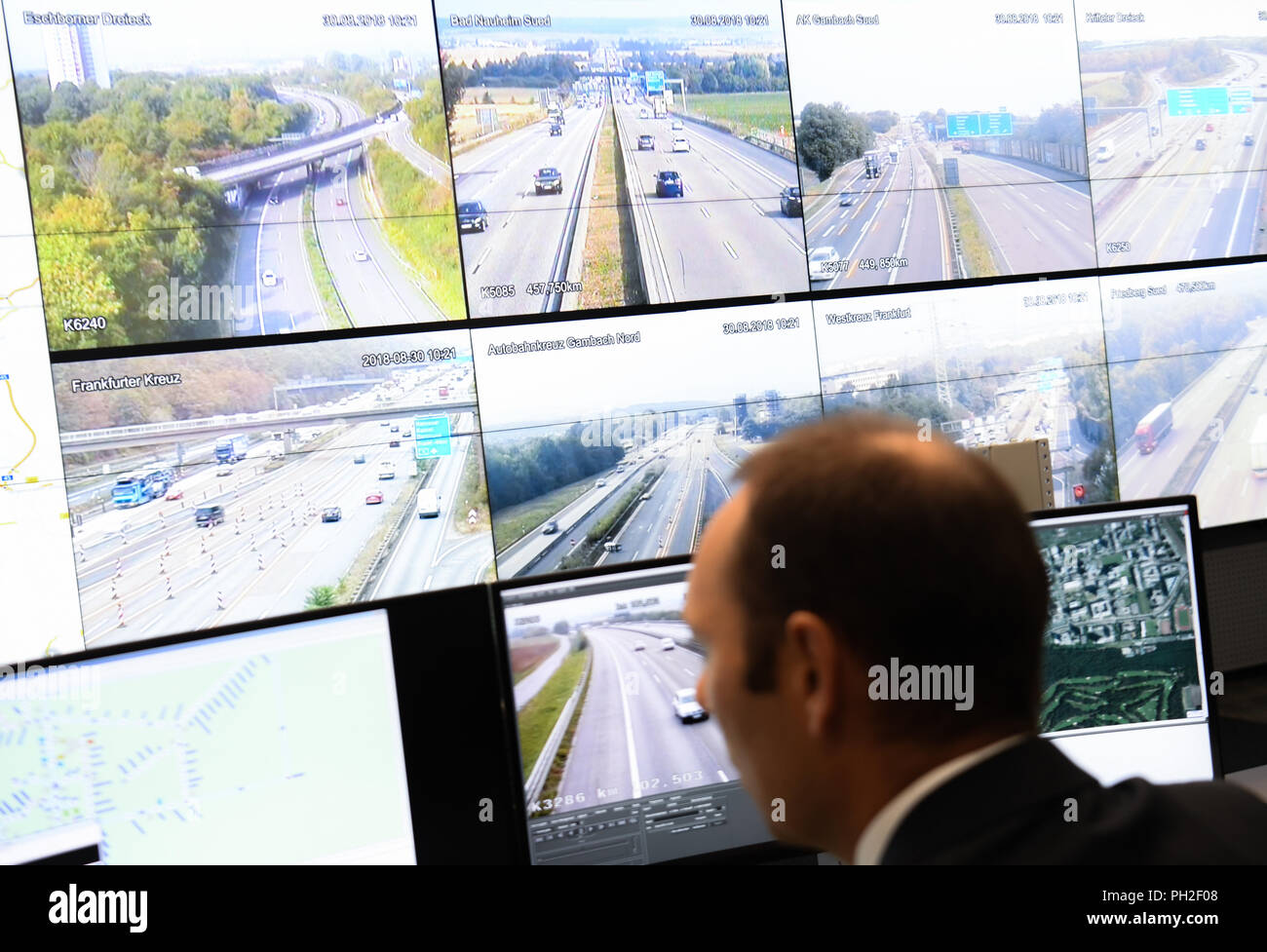 30. August 2018, Frankfurt am Main, Deutschland: Operator Hans-Jürgen Schopf beobachtet, überwacht mit live Bilder der Hessischen Autobahnabschnitten an seinem Arbeitsplatz in der neuen Leitwarte der Hessischen Verkehrszentrale im Haus der Logistik und Mobilität (Holm) am Frankfurter Flughafen. Von seinem neuen Standort, die Hessen Mobil Verkehrsbehörde steuert und lenkt den Verkehr auf den Autobahnen in Echtzeit. Foto: Arne Dedert/dpa Stockfoto