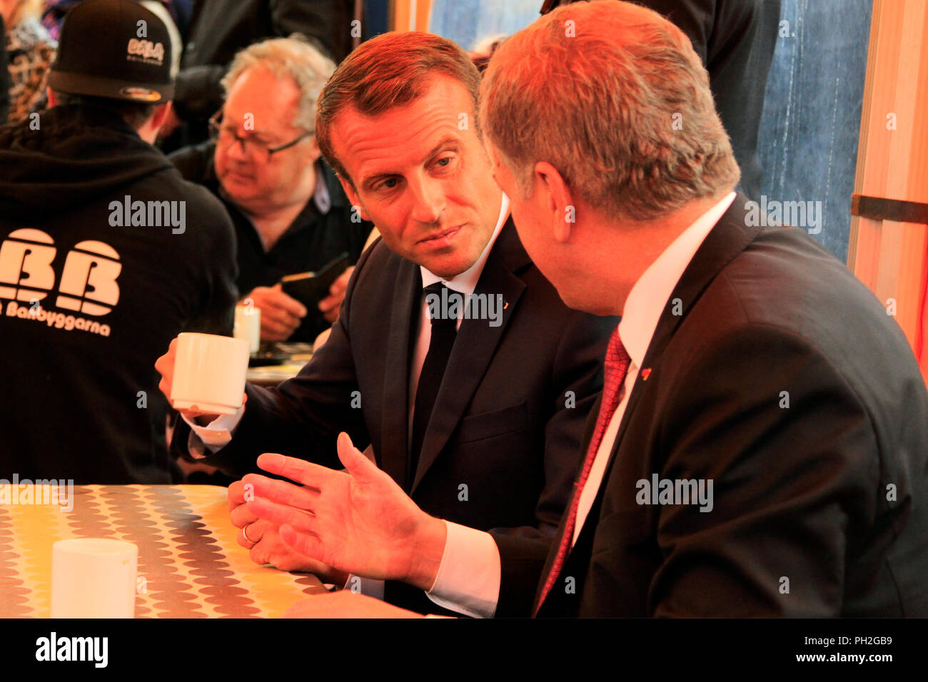 Helsinki, Finnland. August 30, 2018. Der französische Präsident Emmanuel Längestrich (C) und der finnische Präsident Sauli Niinistö (C-R), eine Tasse Kaffee in einem kleinen Marktplatz Cafeteria nach ihrer gemeinsamen Pressekonferenz. Credit: Taina Sohlman/Alamy leben Nachrichten Stockfoto