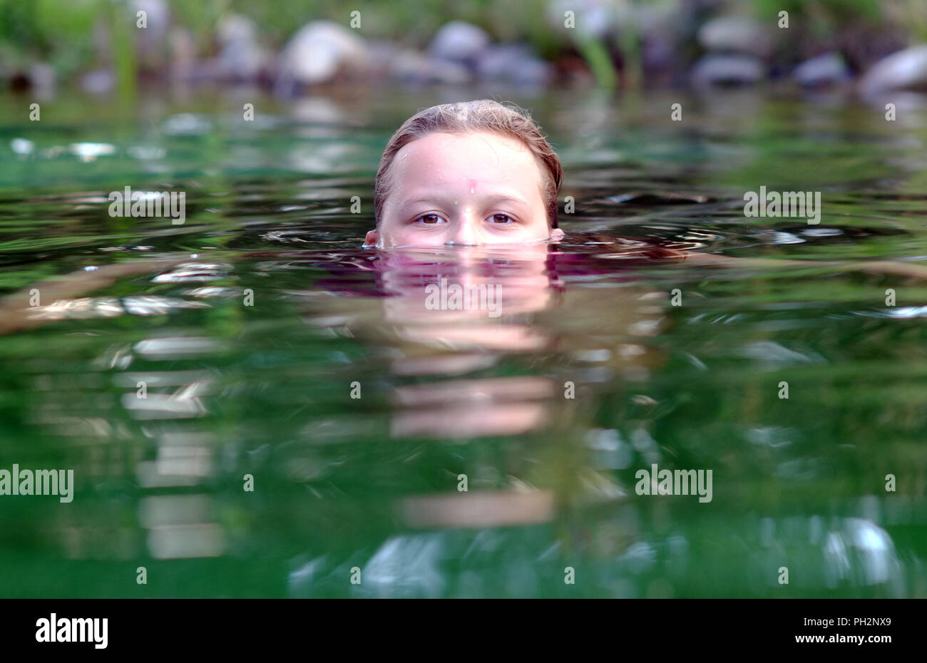 Mädchen halb unter Wasser schwimmen in einem natürlichen Pool. Stockfoto