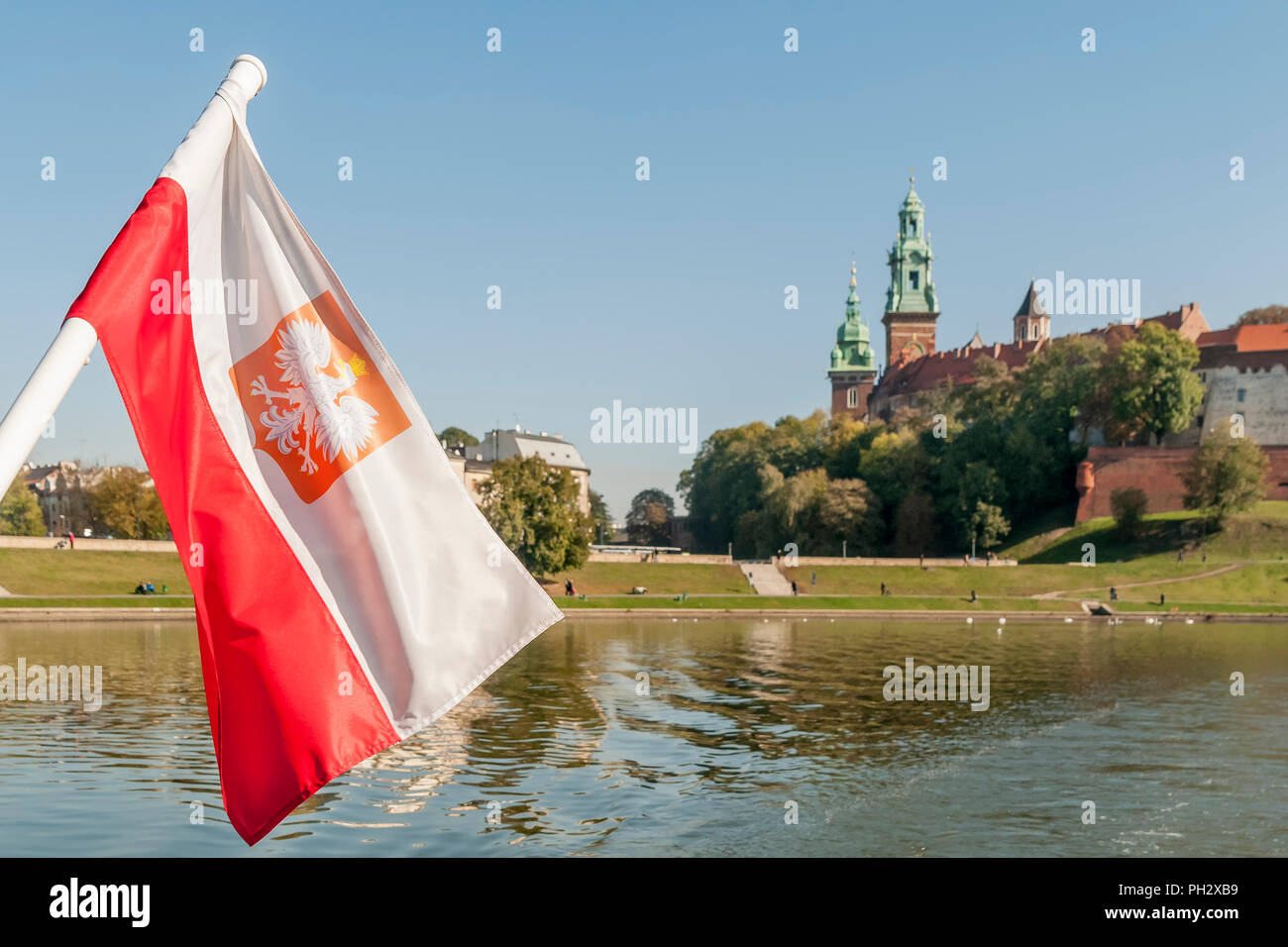 Die polnische Flagge weht auf der Weichsel mit dem Zentrum von Krakau im Hintergrund, Polen Stockfoto