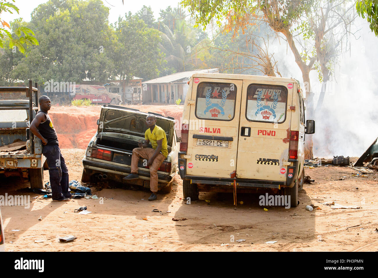 Straße nach Bissau, GUINEA B.-Mai 1, 2017: Unbekannter lokaler Mann lehnt sich an das Auto in einem Dorf in Guinea Bissau. Immer noch viele Menschen im Land leben Stockfoto