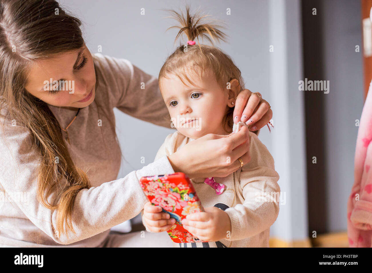 Mutter Kleider ihr kleines Mädchen bei Real home Stockfoto