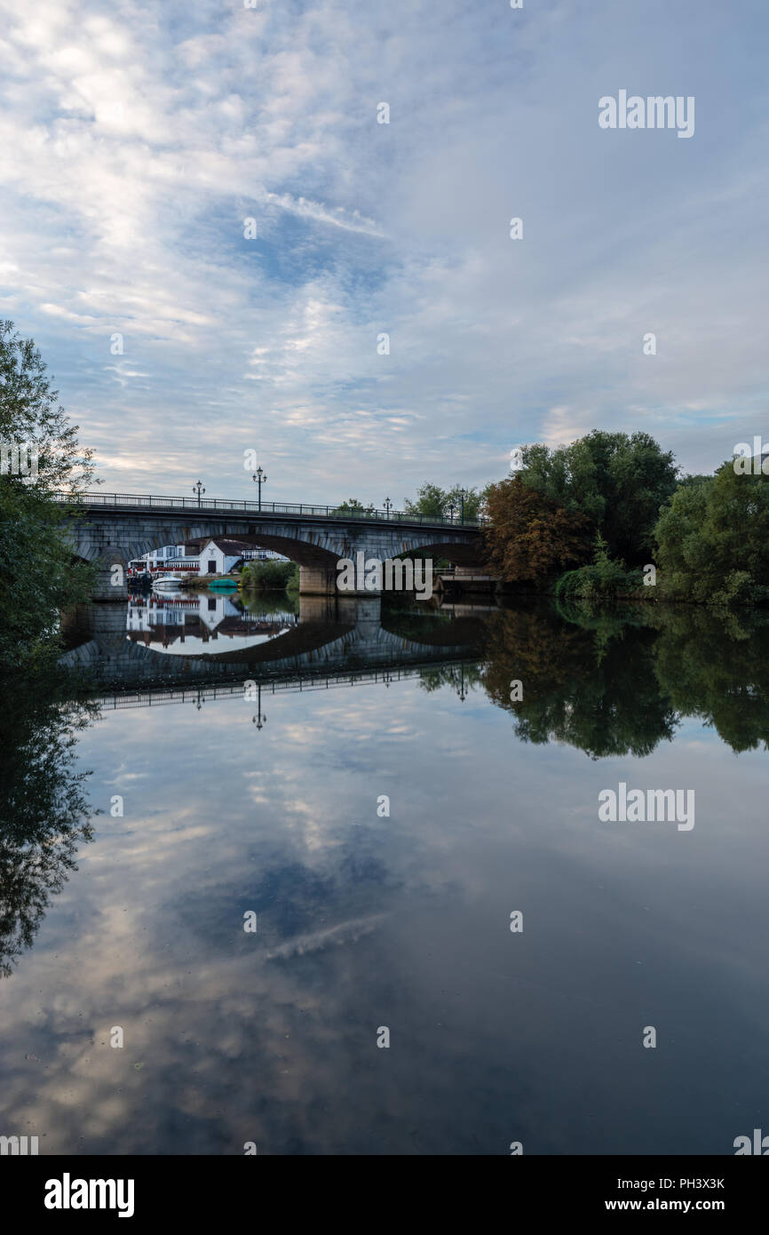 Morgen Himmel und Wolken in der Themse von Staines Brücke in der Morgendämmerung, Swan Hotel/Public House im Hintergrund reflektiert Stockfoto
