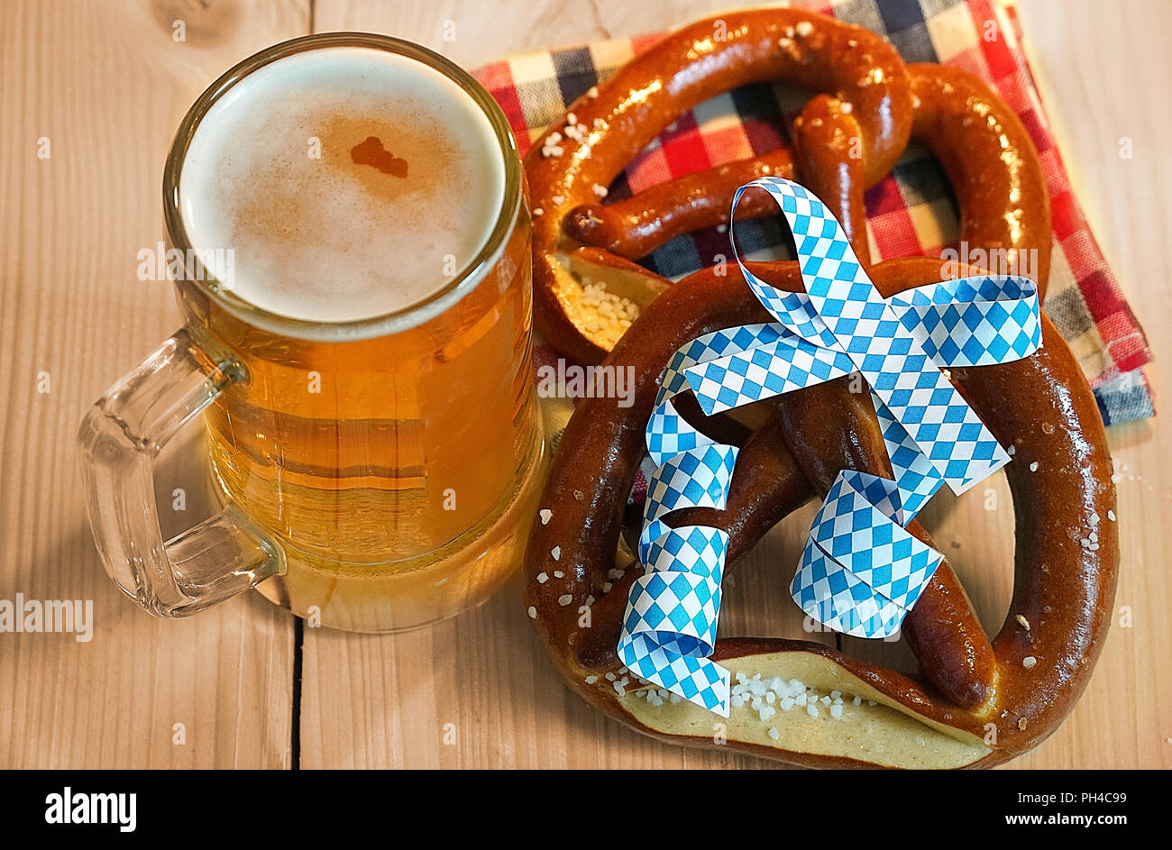 Brezel mit einem Glas Bier auf Holz Tisch für das Oktoberfest. Stockfoto