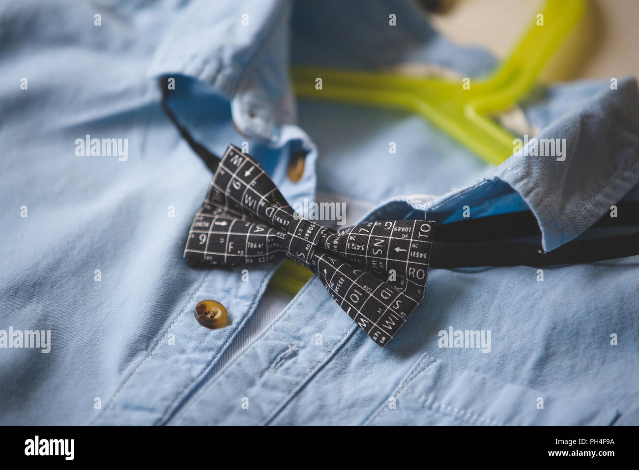 In der Nähe von blauen Hemd mit Fliege auf einem Kleiderbügel. Schwarze Fliege mit wissenschaftlichen Symbolen. Kleidung. Besonderen Anlass passen. Kleidung auf einem Kleiderbügel. Stockfoto
