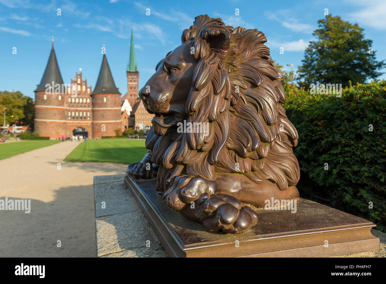 Bronze Lion Statue vor Holstein Tor (Holstentor) in Lübeck, Schleswig-Holstein, Deutschland Stockfoto