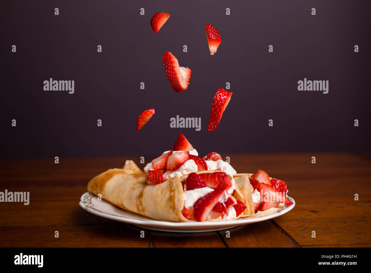 Köstliche Crêpes gefüllt mit Erdbeeren und Schlagsahne mit Erdbeeren der auf der Oberseite des Crepes. Stockfoto