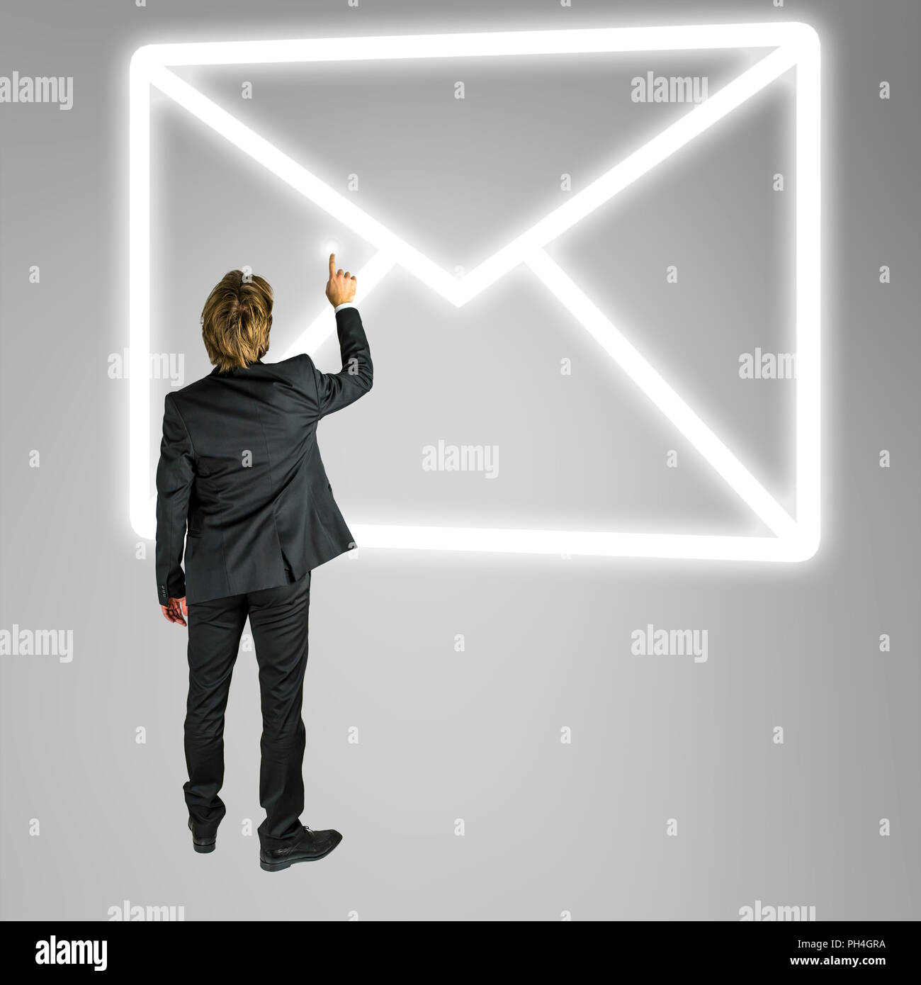 Unternehmer stehen vor einem Umschlag mail Symbol auf einem virtuellen Bildschirm oder Schnittstelle konzeptionelle von online Kontakt und Kommunikation Stockfoto