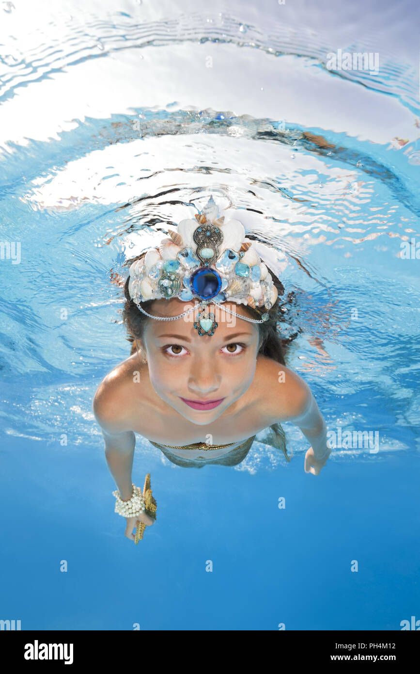 Ein Mädchen in einer Meerjungfrau Kostüm wirft Unterwasser in einem Pool  Stockfotografie - Alamy