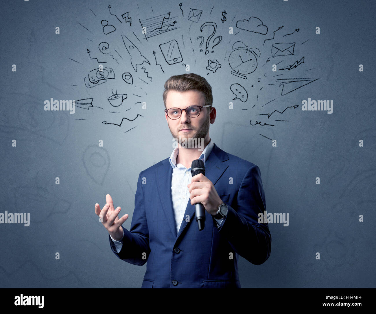 Geschäftsmann sprechen in das Mikrofon mit gemischten Doodles über seinem Kopf Stockfoto