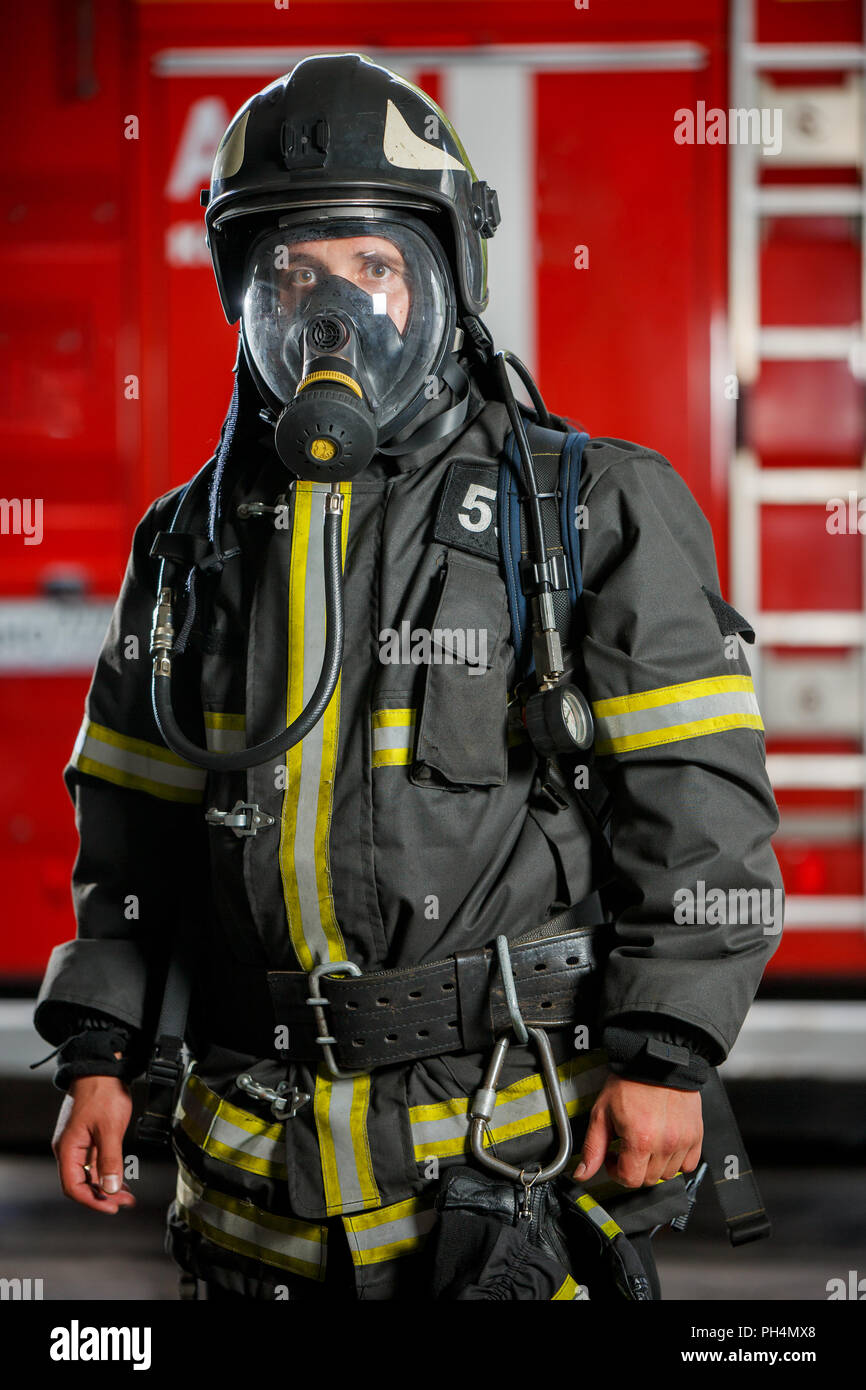Foto von Feuerwehrmann in Gasmaske und Helm in der Nähe von Feuer Motor  Stockfotografie - Alamy