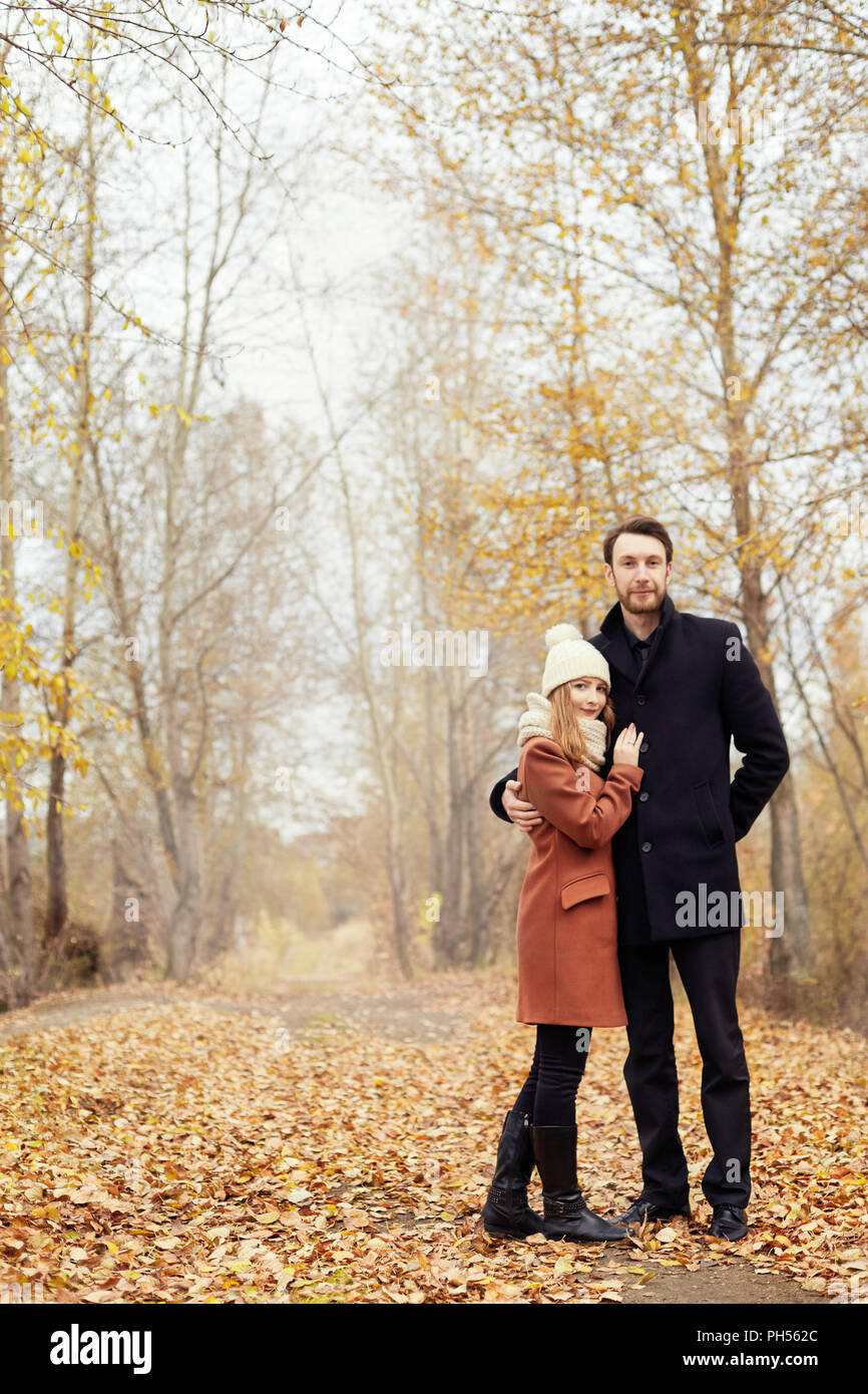 Paar in der Liebe Wandern im Herbst Park, kühlen Herbst Wetter. Ein Mann und eine Frau umarmen und küssen, Liebe und Zuneigung, Gelb Herbst Landschaft Stockfoto